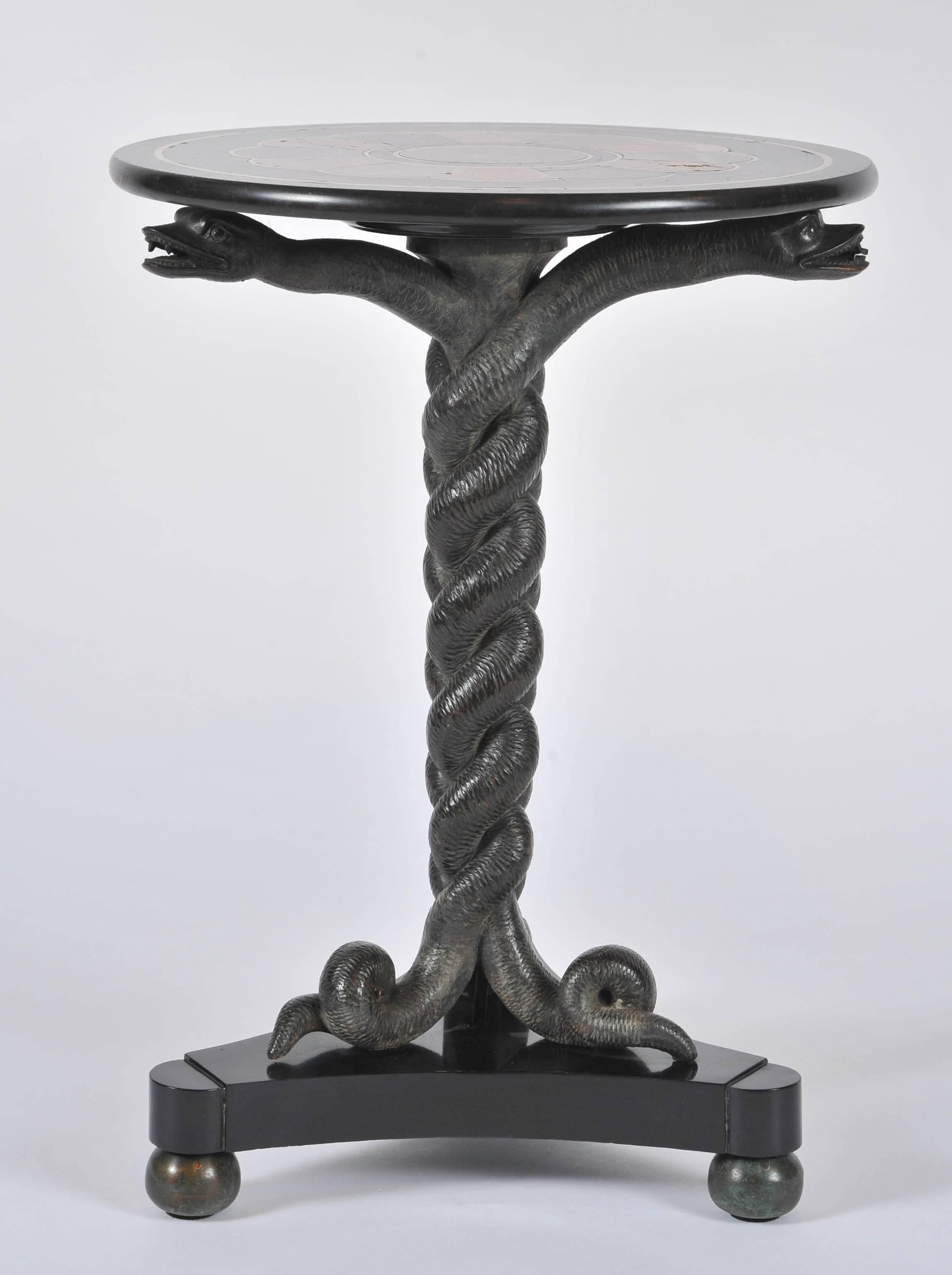 An exceptional Regency period table with specimen marble top supported by three intertwined serpents, on a triform base. The serpents carved wood simulating bronze, the base ebonized to simulate bronze and the feet patinated brass in the typical