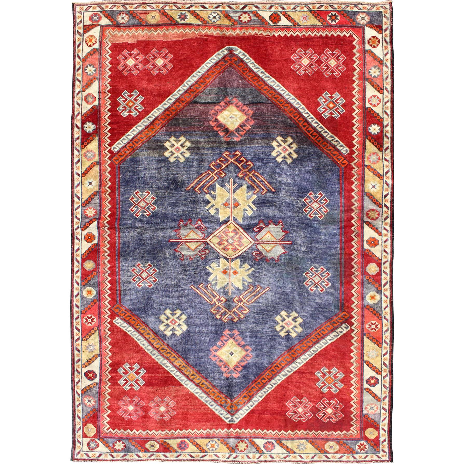 Türkischer Oushak-Teppich mit geometrischem Muster auf blauem und rotem Hintergrund