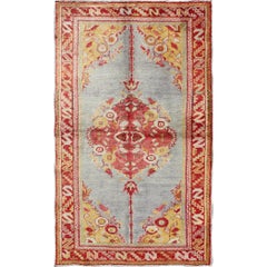 Tapis turc vintage d'Oushak avec médaillon à fleurs et corniches sur fond gris clair