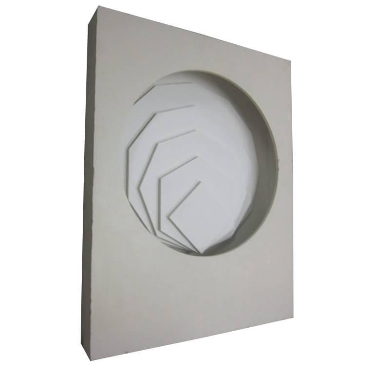 Rare Italian 1970 wall-mounted sculpture or light box. . The sculpture is composed of a rectangular box with a circle cut-out. Inside the circle and mounted to the back is a series of succeeding geometric forms (rectangular, hexagonal, octagonal,