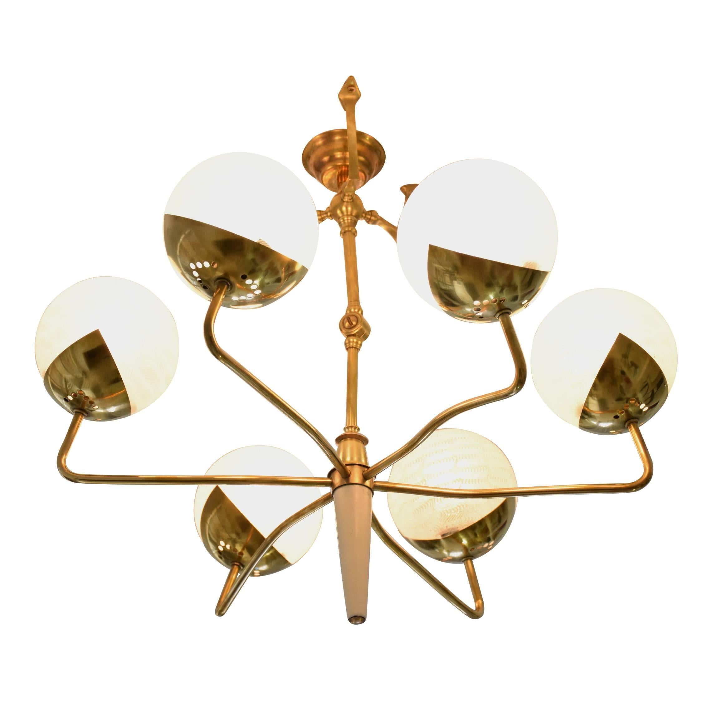 A six-arm 20th midcentury vintage chandelier or flush mount composed of an articulating spider-like gold polished brass structure with feet shaped stems and embellished details throughout. The cone-shaped ending is composed of lacquered brass. The