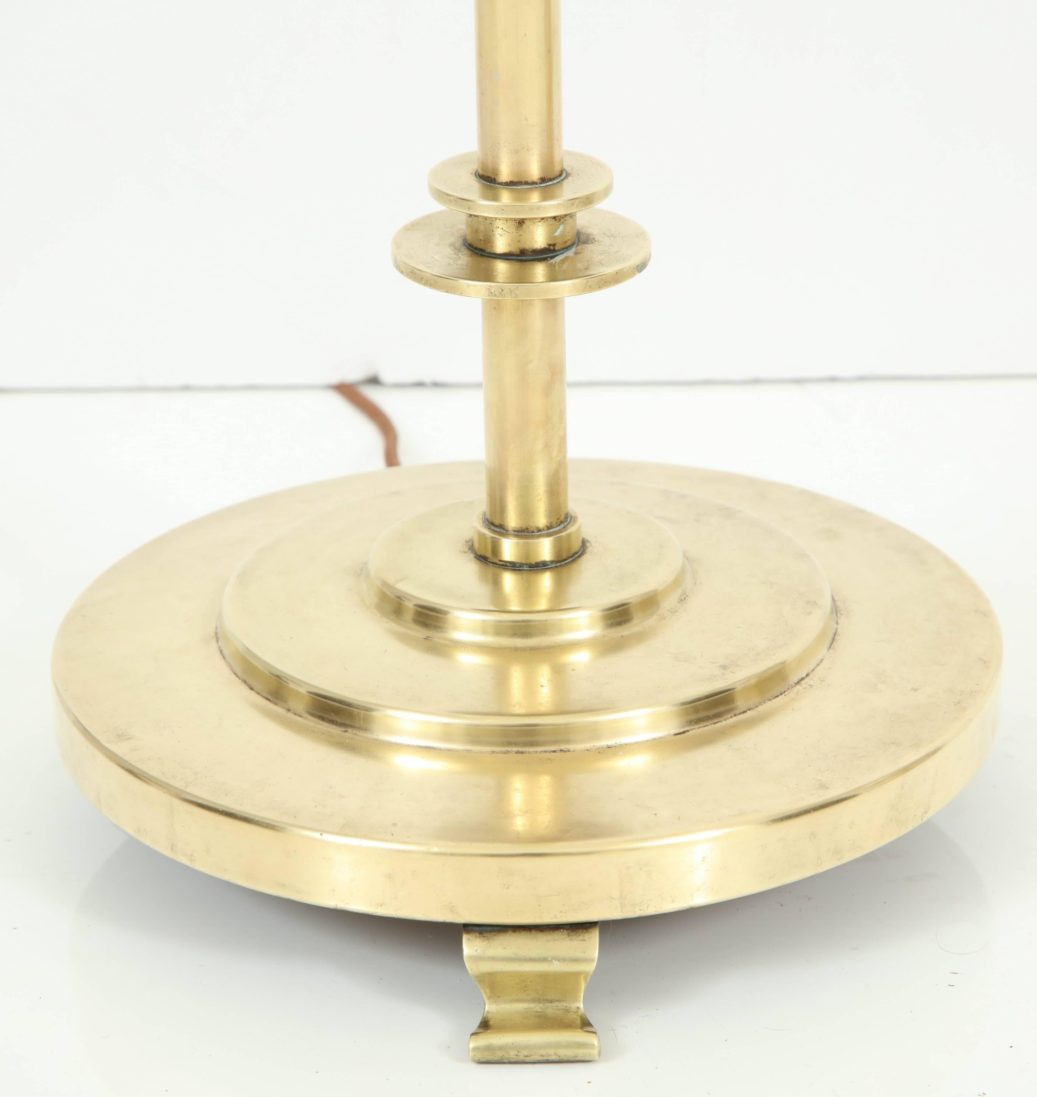 A brass floor lamp, Copenhagen, circa 1930s, with adjustable circular stem raised on stepped circular base. Re-wired for the US.