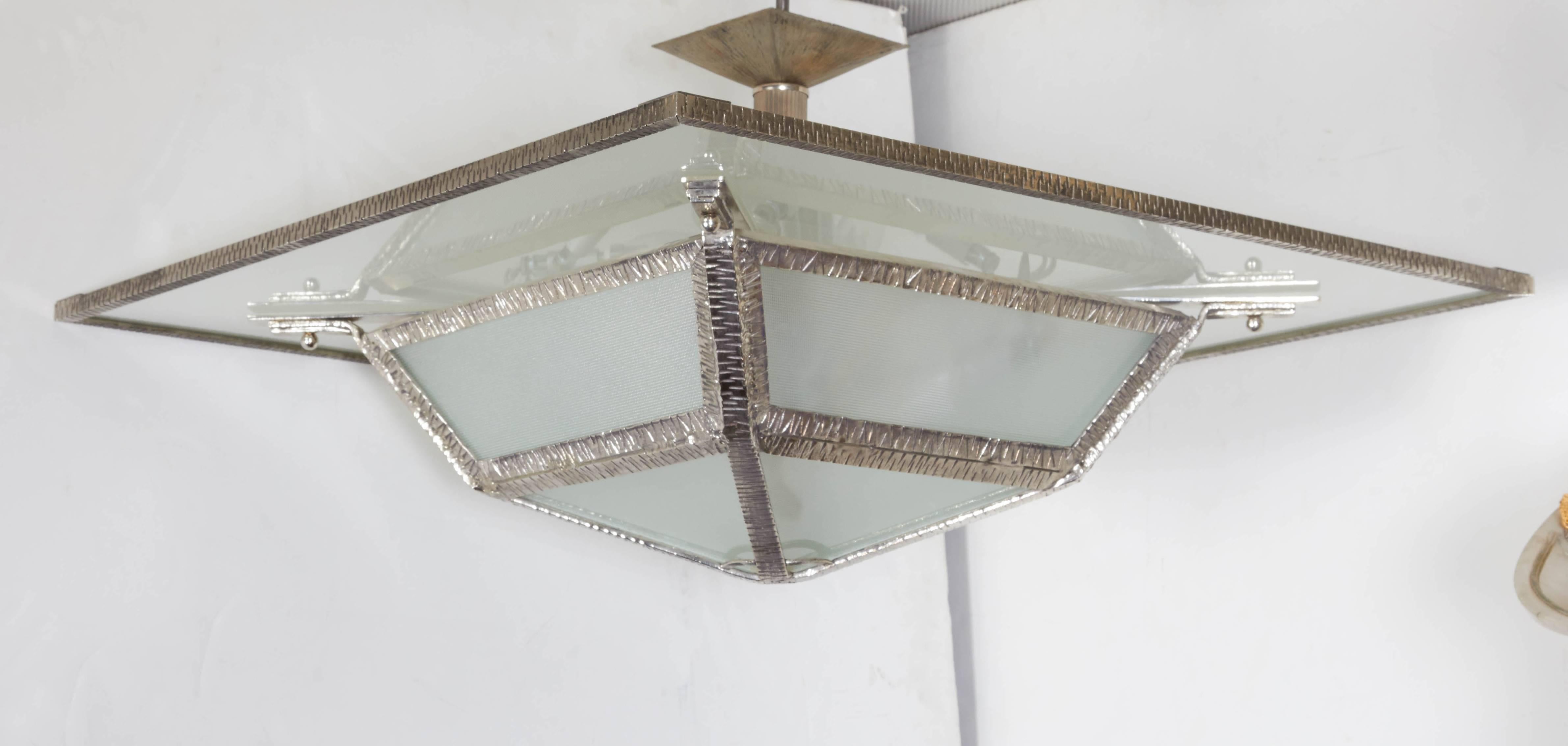 French Modern nickeled iron, bronze and glass chandelier; clean, architectural and modern in design. Overall square shape with pyramid bottom. 
This chandelier hovers right under the ceiling like a flush mount. 
Can even be shortened a bit more or