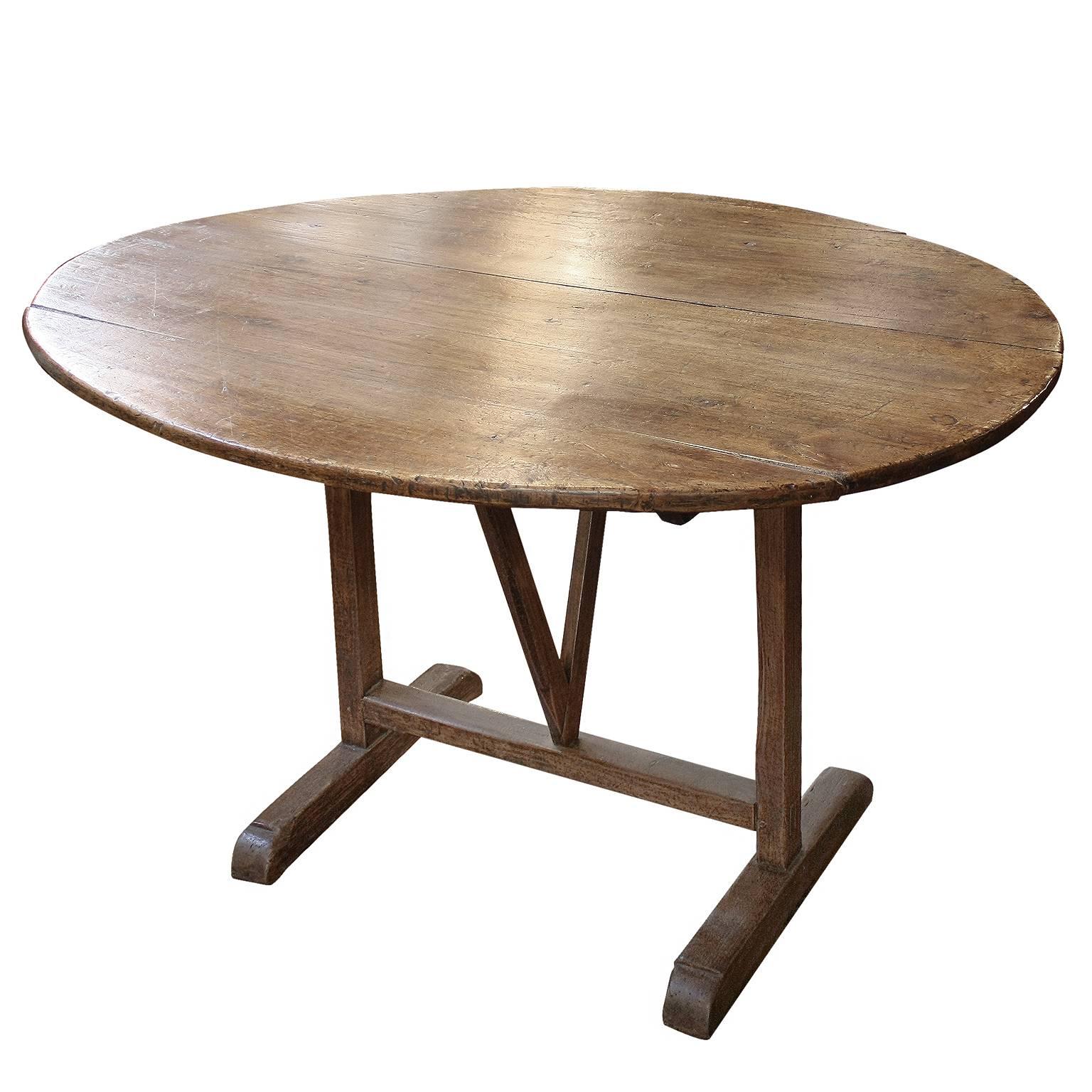 A European contemporary oval shaped elm and poplar wine tasting table. We're always looking to find good looking wine tasting tables and we weren't disappointed when we found this oval shaped one. The top is raised on an H-form base with butterfly