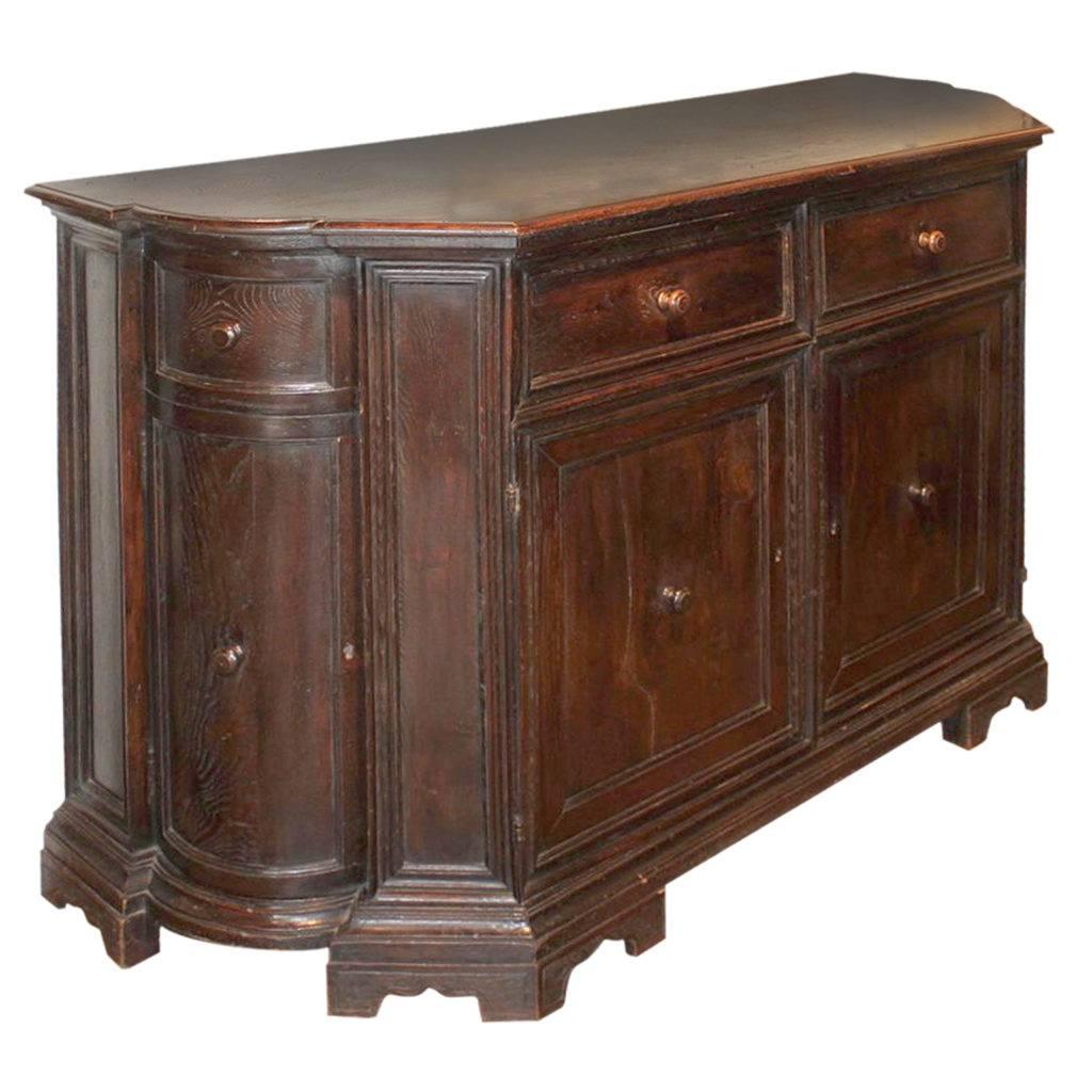 This European walnut credenza from the mid 19th century features two drawers over a double door. The contoured top is very slightly raised and surrounded by a rounded edge. Two drawers sit atop two doors. The side posts, evoking simple pilasters,