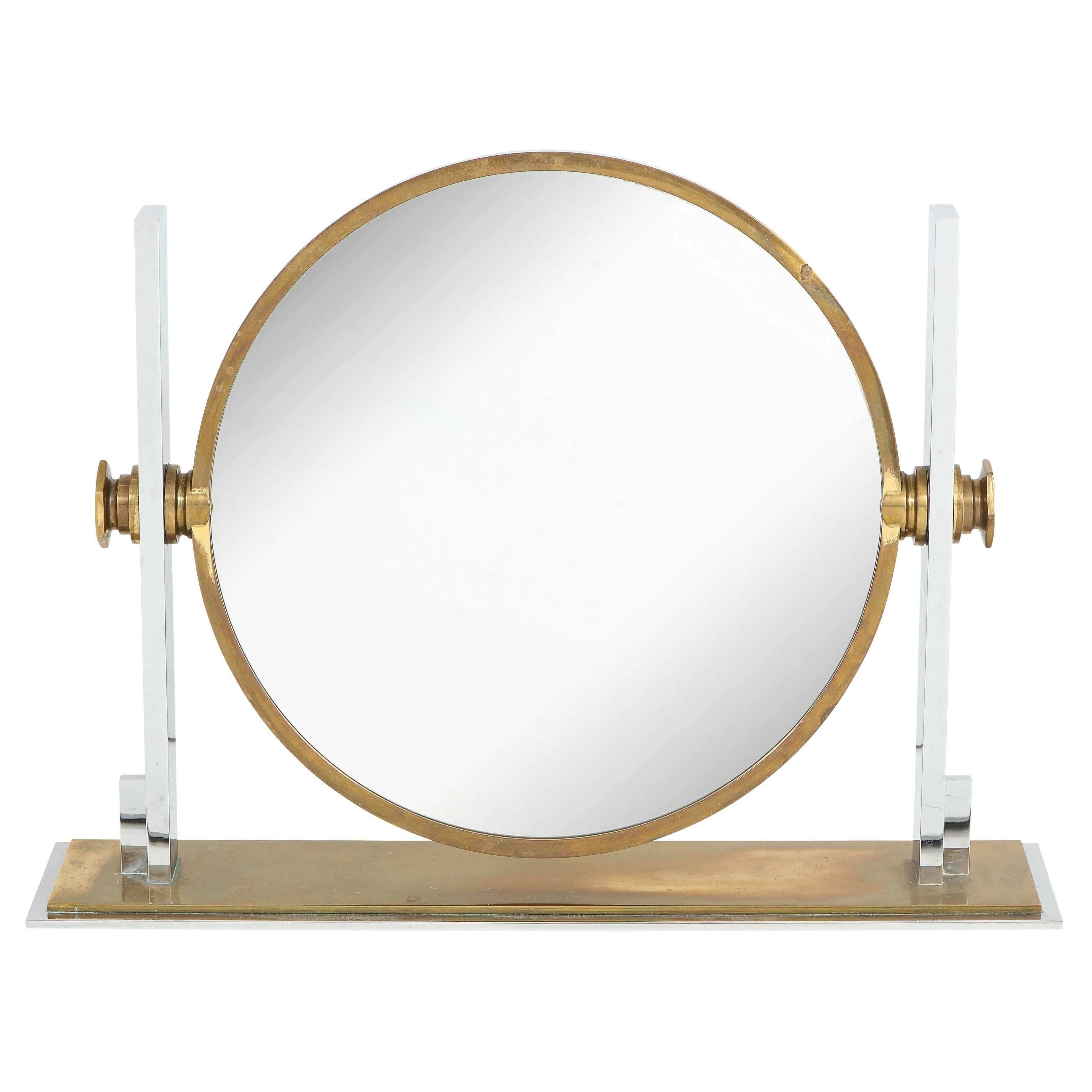 Karl Springer mirror, brass chromed steel, convex. Large-scale table top or vanity mirror in original condition with natural aged patina to the brass. The revolving mirror is adjustable and flips from a flat side to a convex side for a magnified