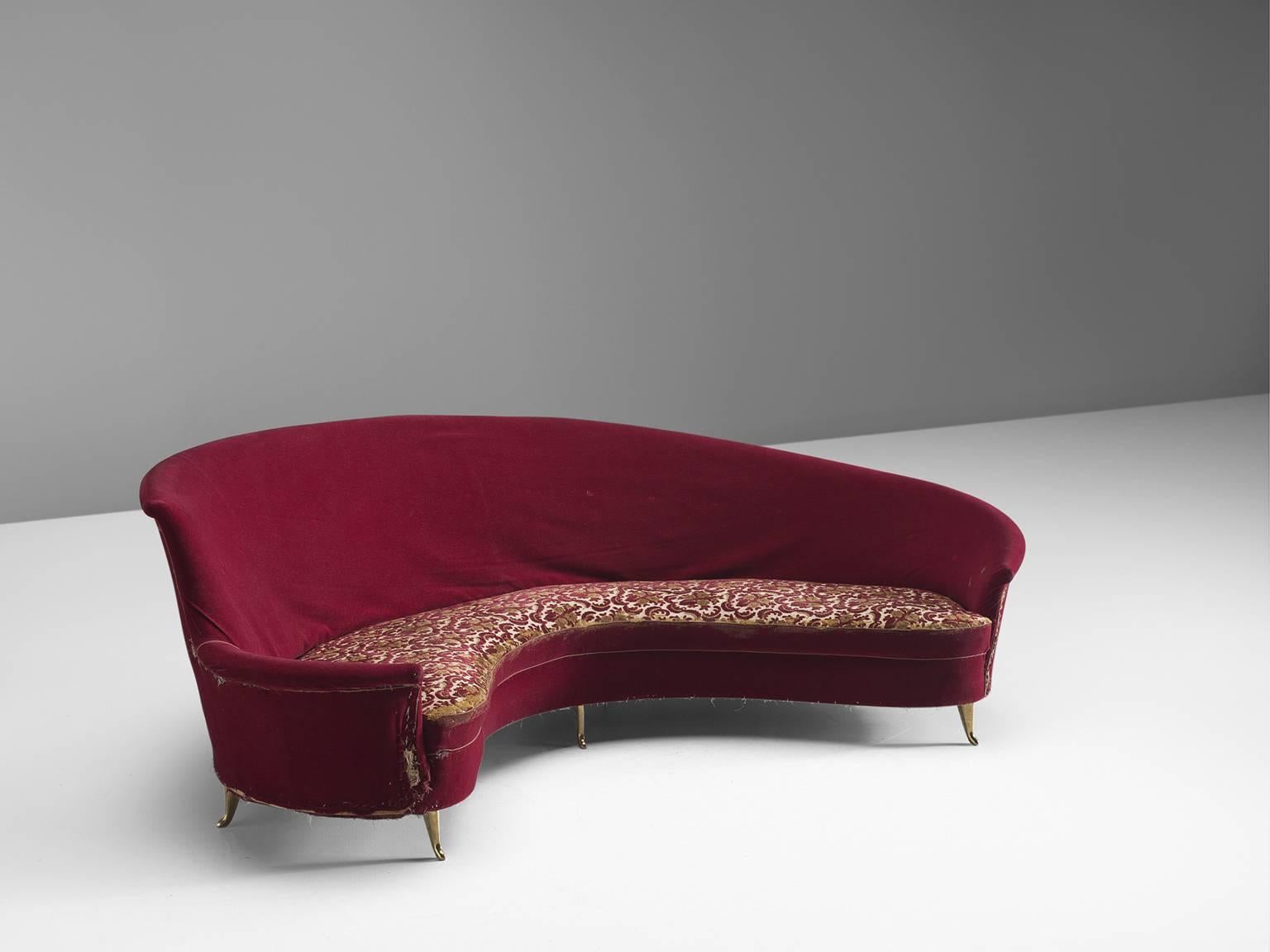 Settee, red and floral fabric (re-upholstery needed) and brass, Italy, 1950s

This dynamic sofa features an a-symmetrical back that is higher on the left side and slowly slopes towards much lower end on the right side. The six tapered delicate