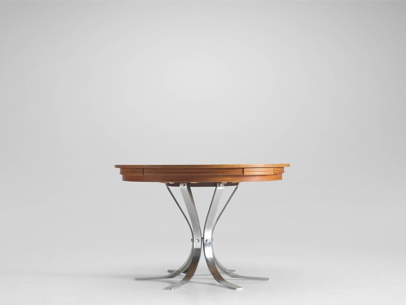 Round extend-able pedestal table, teak and steel, Dyrlund, Denmark, 1960s.

This circular, extendable table has a pedestal chrome base in a six star model and is finished with a teak top. The top has the ability to extend in diameter. Four fold-able