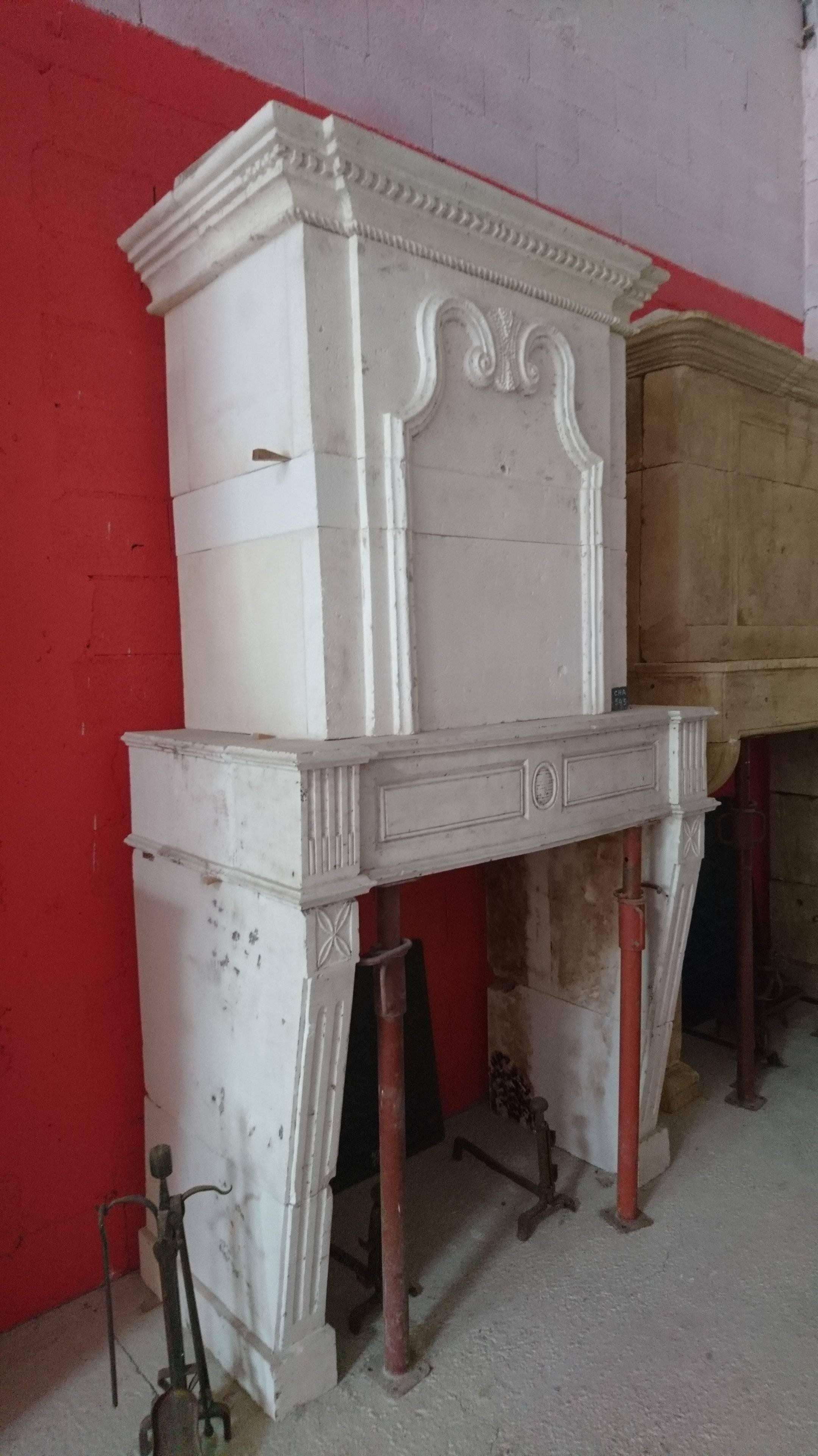 This elegant antique fireplace with trumeau reveals the skilled craftsmanship of the former stonecutter of the 18th century that carved it into the stone of Saint-Vaise (a white natural limestone once excavated in subterranean quarries in the South