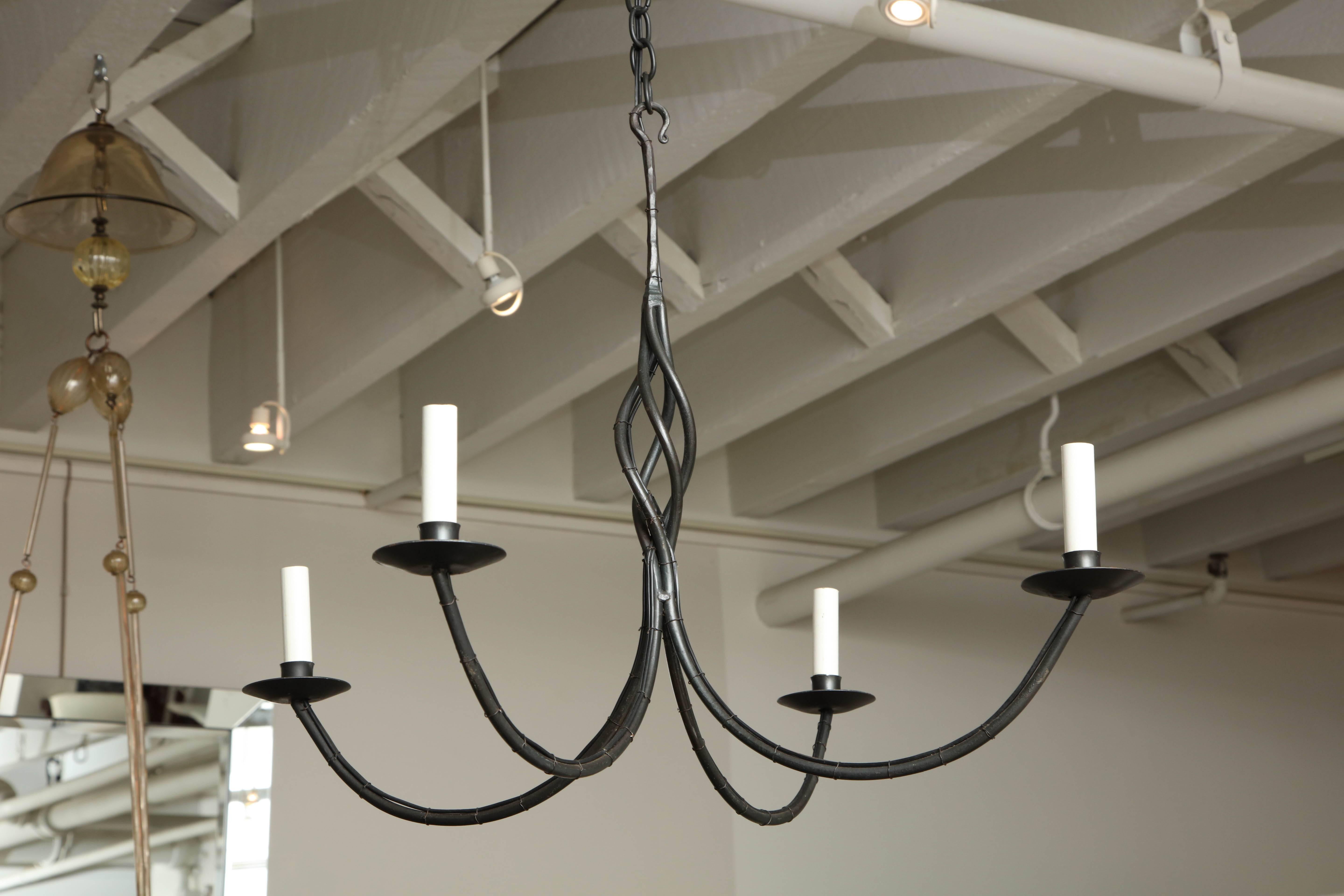 Exceptional contemporary American four arm black wrought iron chandelier.