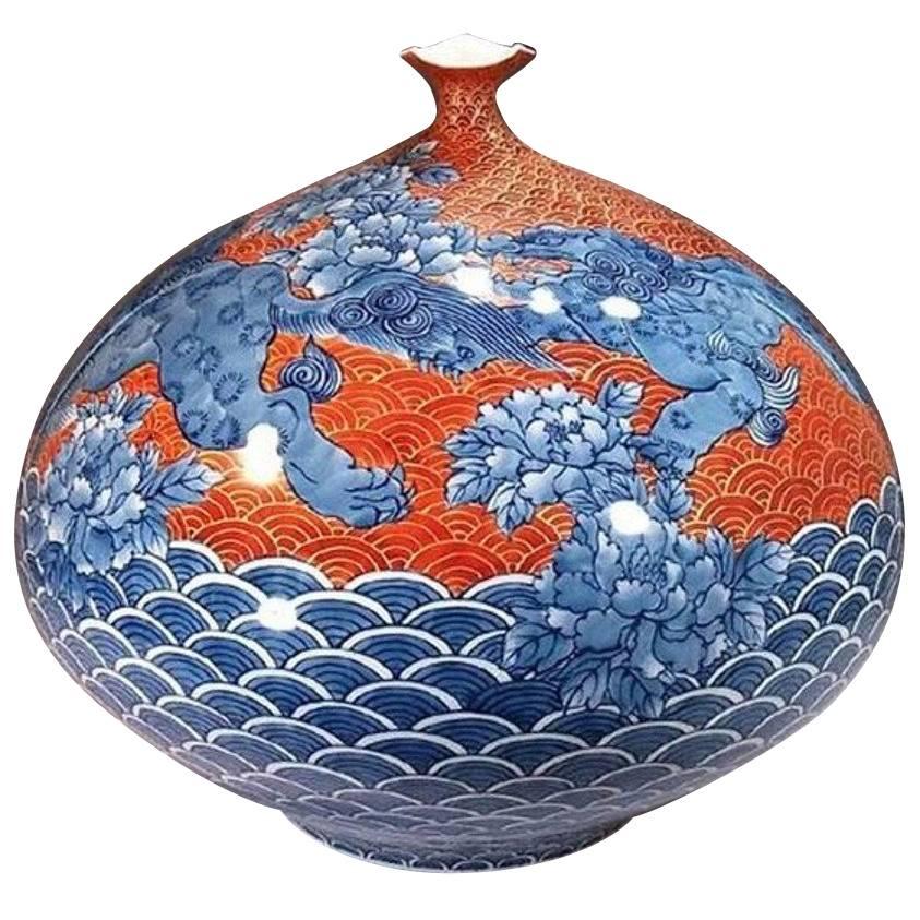 Grand shishi lions in blue with impressive details in darker shades of blue soar above the fish scales representing the universe. Shishi lions symbolize power and strength. Giant peonies with intricate details, symbolizing royalty and wealth,
