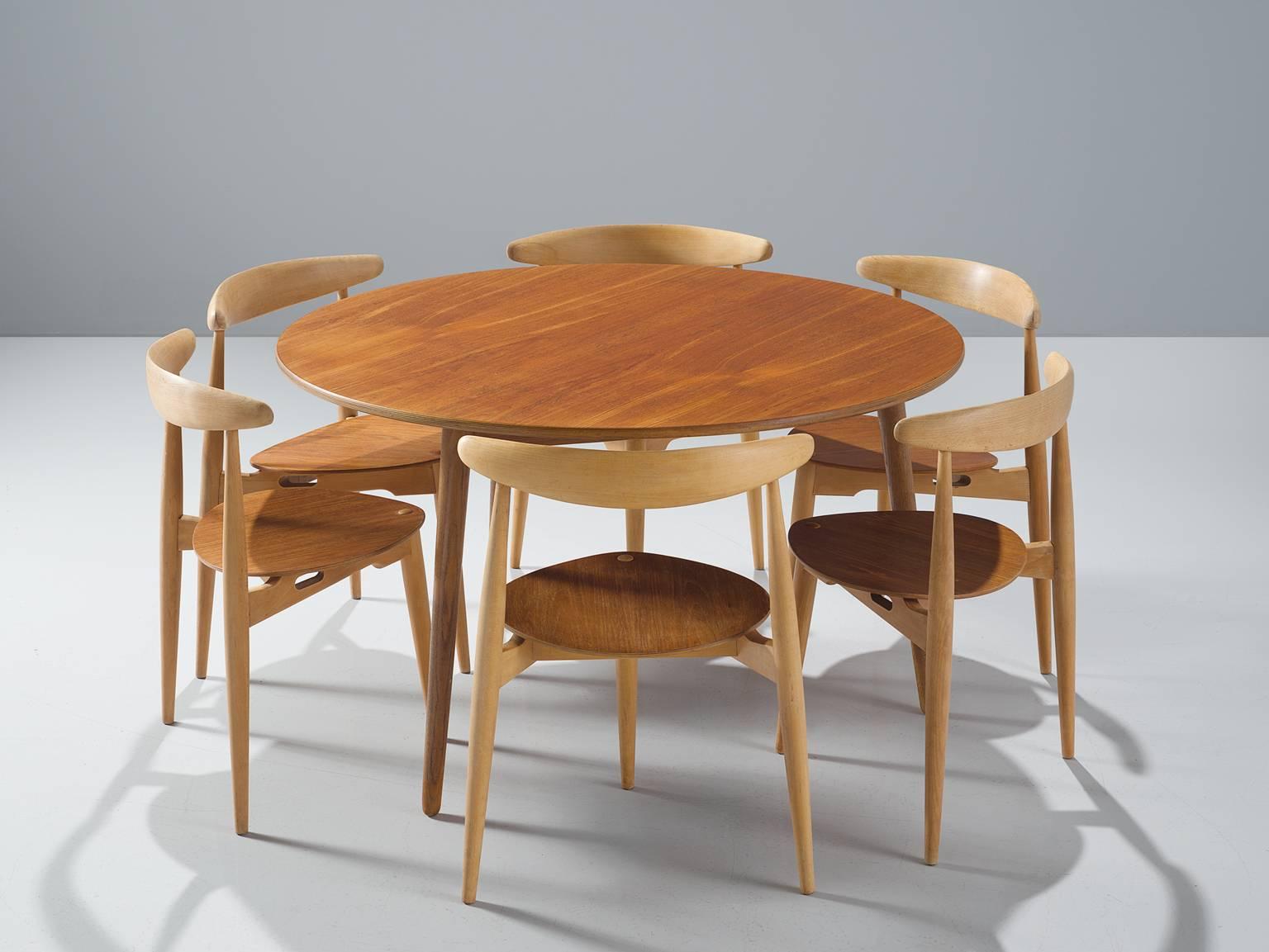 Heart set by Hans Wegner for Fritz Hansen, beech and teak, Denmark, 1953.

This set is part of the midcentury collection. The chairs by Hans Wegner are designed to sit flush against a table. The chairs have only three legs, so they can be shoved all