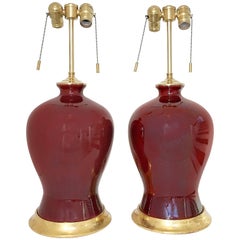 Pair of Sang De Bouef Oxblood Red Ceramic Lamps with Giltwood Bases