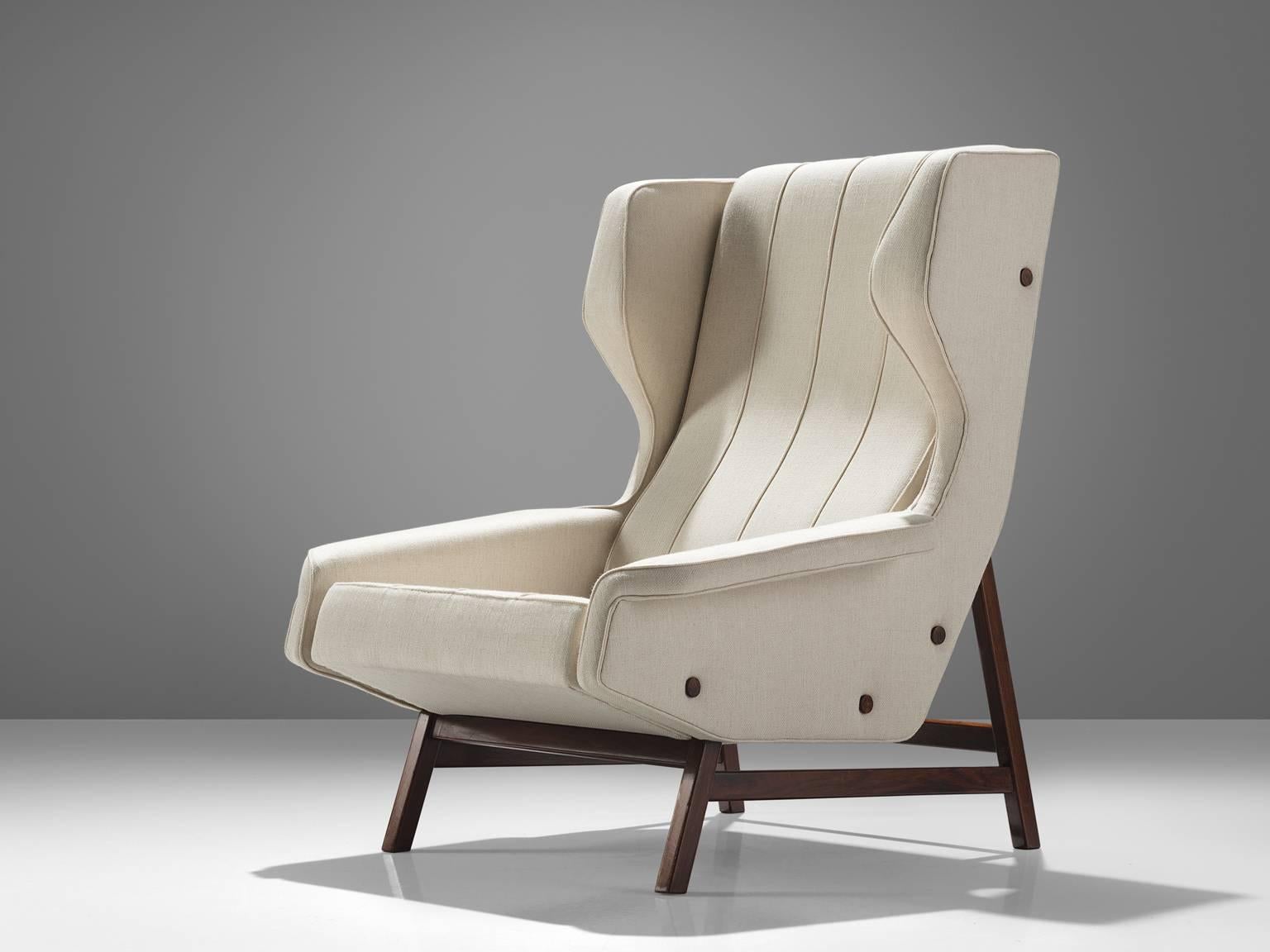 Gianfranco Frattini for Cassina, lounge chair model 877, fabric, rosewood, Italy, 1959.

Sturdy and voluminous lounge chair in white fabric, reupholstered in our in-house workshop. This wingback chair shows nice details and elegant lines. The