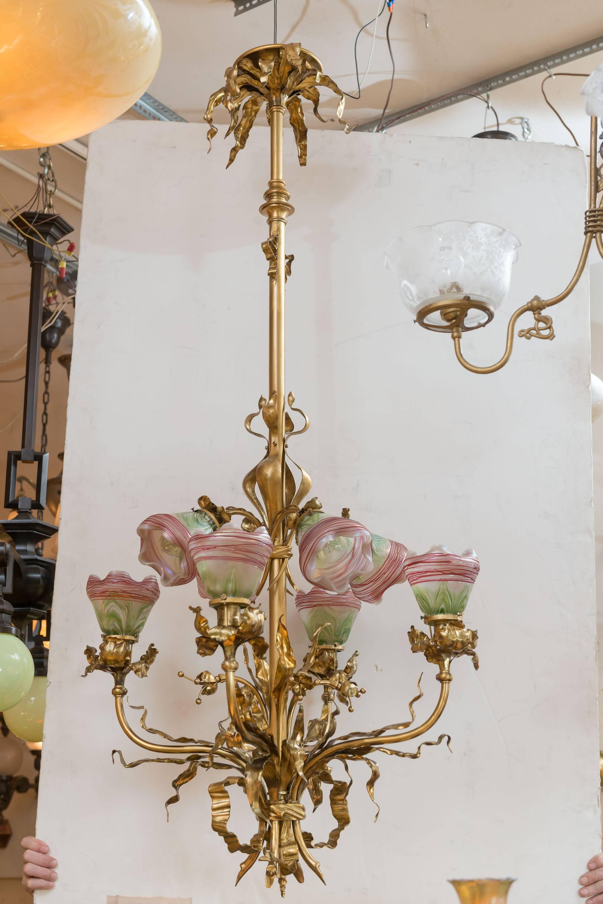 This is certainly one of the best chandeliers we have in our shop, and we have over 100 chandeliers. The metal work is dazzling with leaves and vines everywhere, and all done in a rich gilt finish. The glass shades are known as pulled feather style,