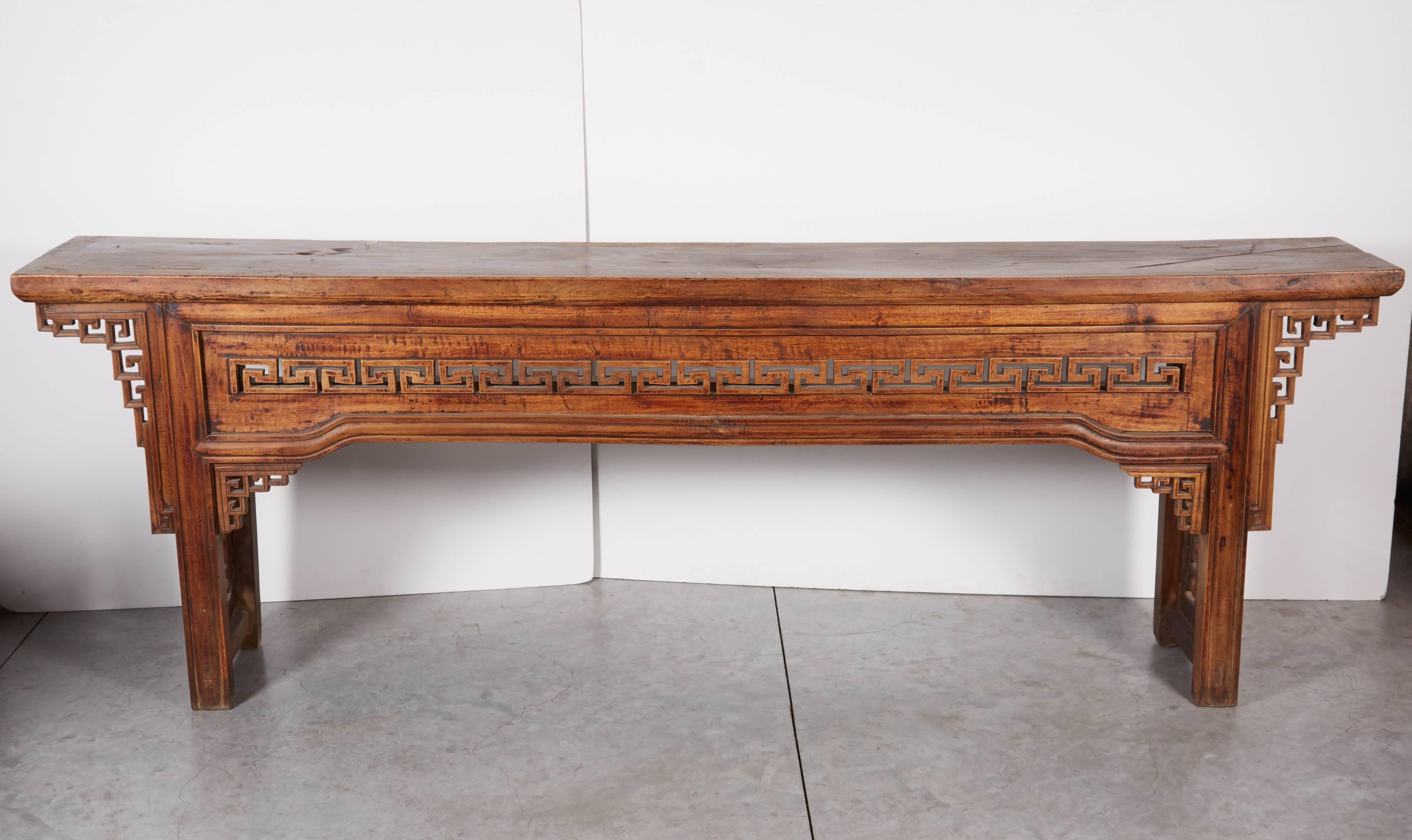 An unusual 19th Century Chinese walnut altar table with simple decorative carvings. This piece has a solid walnut top with a remarkably beautiful patina. From Xian, c. 1850.
T515