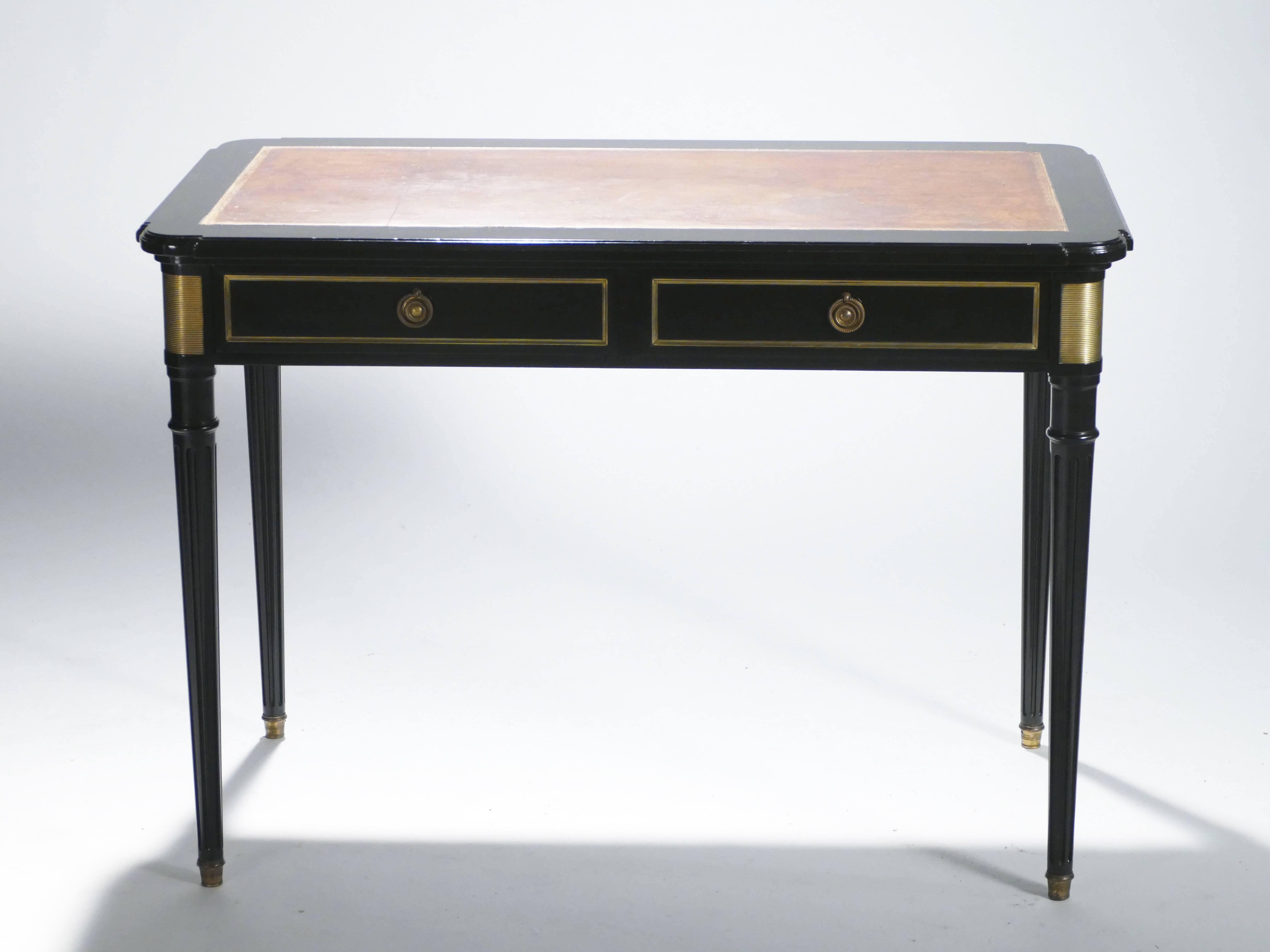 This attractive writing desk is signed by French designer Maurice Hirsch. With its sleek rectangular shape and fluted feet, this piece is typical of the designer’s neoclassical work. Beautiful re-varnished ebony wood forms the substantial parts of