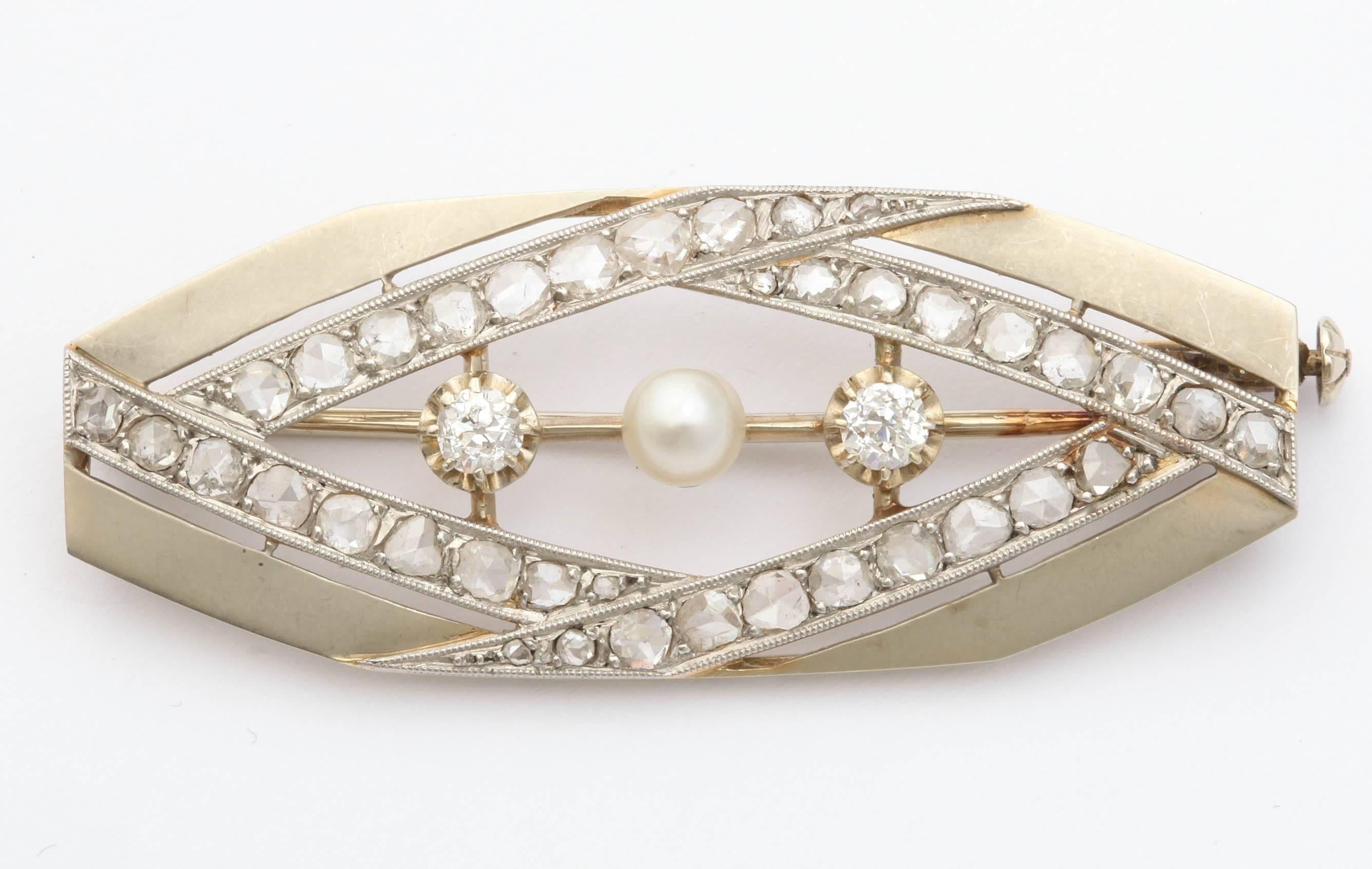 An elliptical 18k gold pin with canted ends enhanced with two European-cut diamonds and a cultured pearl and lines of rose diamonds bead-set in platinum.
 
With French hallmarks

2 in. (5.1 cm.) wide.