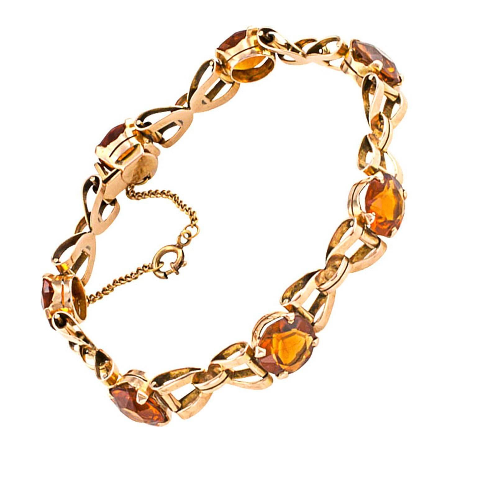 Madeira Citrine and Gold Link Retro Bracelet Circa 1940

18 karat gold open links accented with round dark hued citrines totaling approximately 20.00 carats.  Citrines of this color were extremely popular during the 1940s.  Sometimes they are