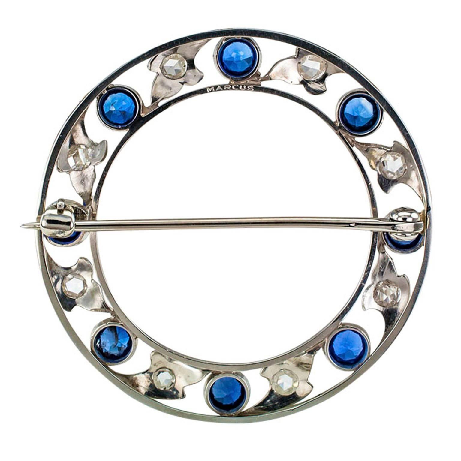 Marcus & Co. Edwardian Blue Sapphire and Rose-Cut Diamond Circle Brooch.

A ribbon of  blue sapphires and rose-cut diamonds mounted in platinum by Marcus & Co circa 1910.  The design evokes a delicate and airy construction shaped into a circular