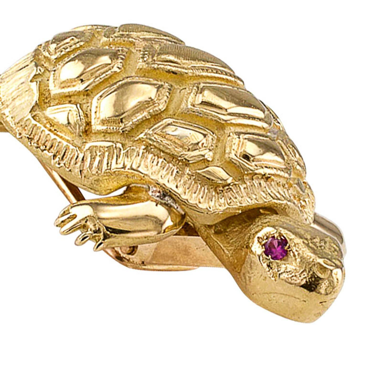 1960s 18 Karat Gold and Ruby Turtle Brooch

Land turtle 18-karat yellow gold clip/brooch with ruby eyes, circa 1960.  For some reason unknown to us, we come across a lot of turtle brooches depicting sea turtles, land turtles not very often.  It is