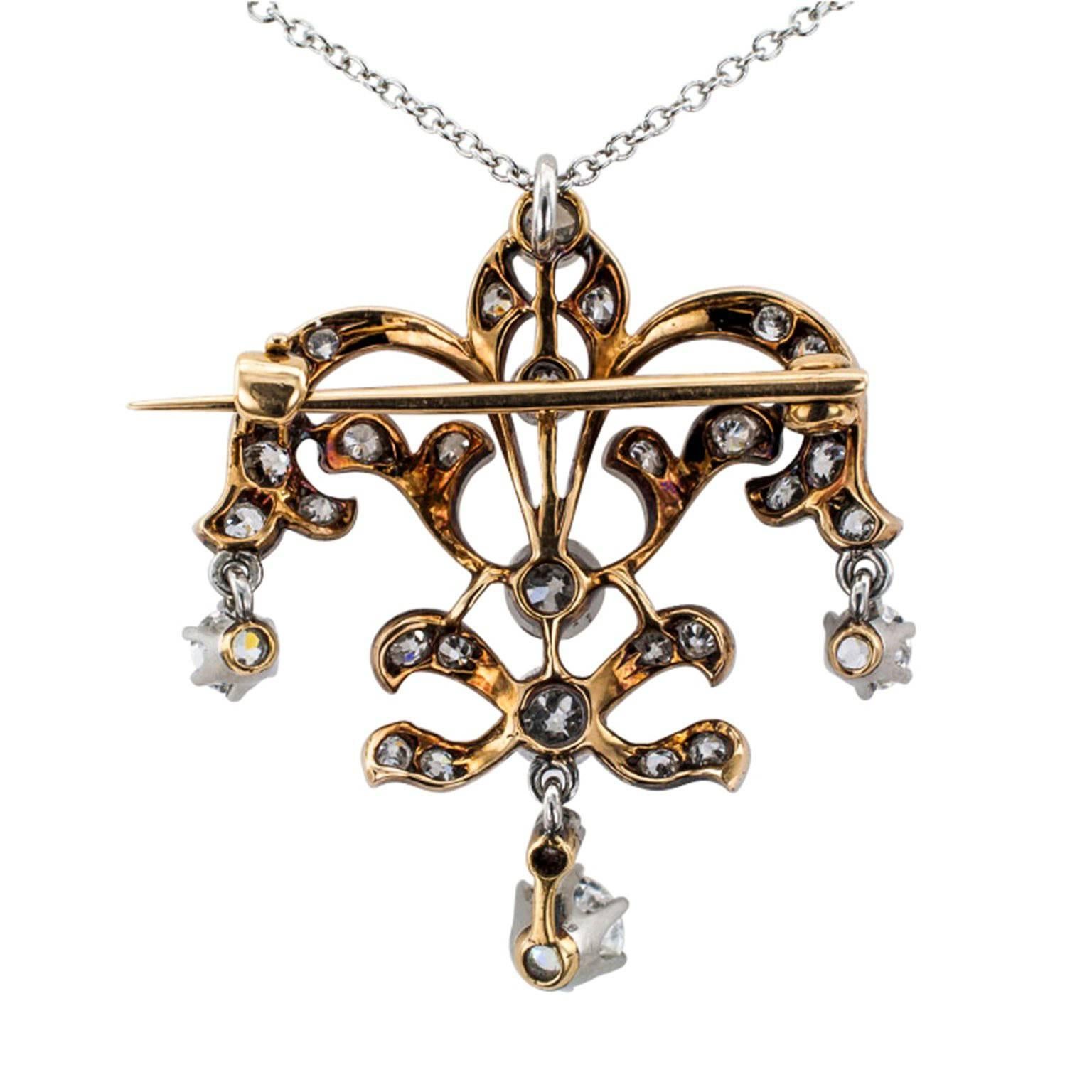 Edwardian Platinum and Gold Diamond Brooch/Pendant

Platinum and 14-karat yellow gold lavaliere-brooch set with diamonds totaling approximately 1.25 carats, circa 1910.  An open work design composed by scrolling motifs completed by a trio of