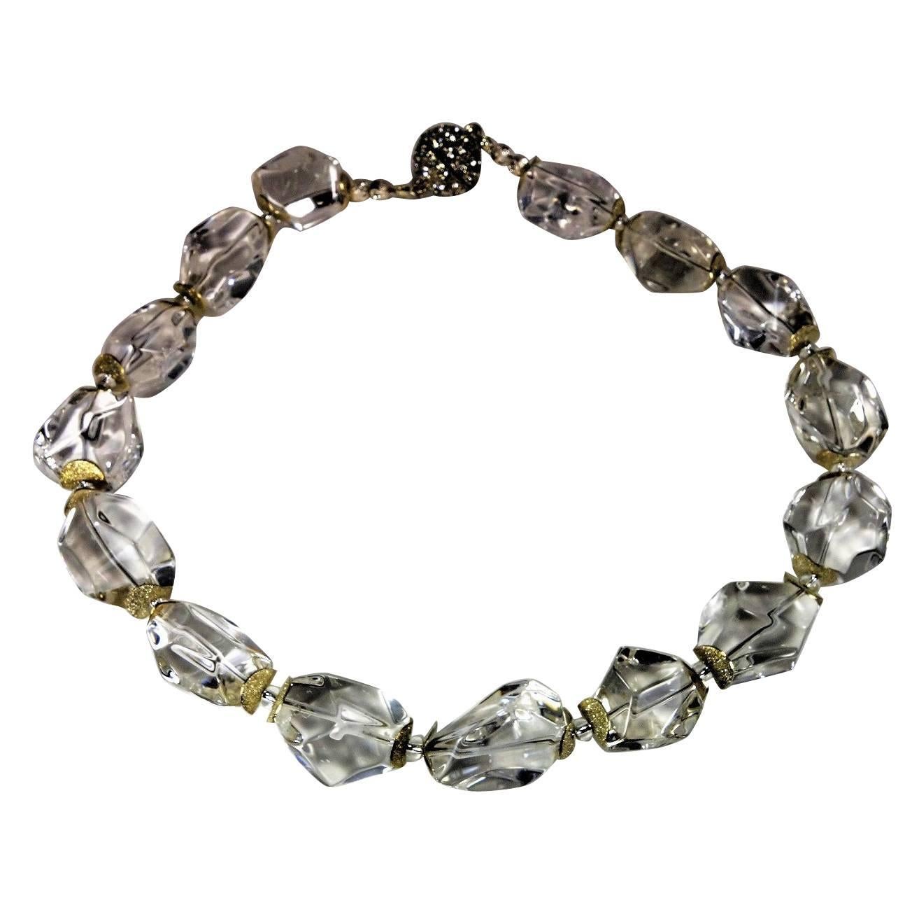 Necklace of Faceted Clear Quartz Crystal Nuggets (approximately 27x22mm).  The nuggets are enhanced with sparkly silver tone flutters and silver Czech beads.  The clasp is a 20mm magnetic sphere with lots of crystal sparkles.  This is a great