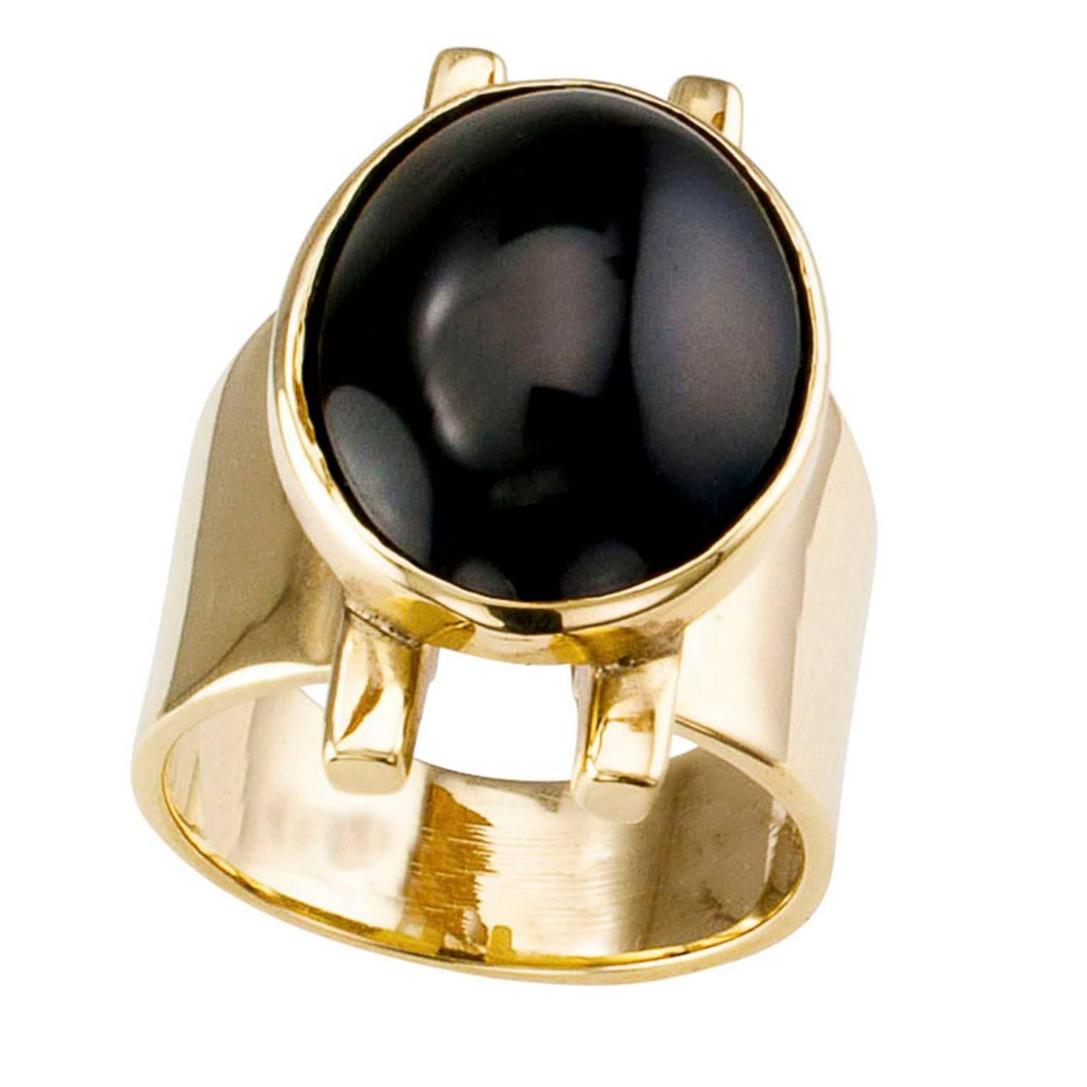 Rigoberto Onyx and Gold Ring

Onyx and gold ring by Rigoberto circa 2000.  The design features parallel lines floating on a wide band with a bezel-set black onyx cabochon vertical to the fingernail.
RING SIZE:  6 1/4, can be sized.
DIMENSIONS: 