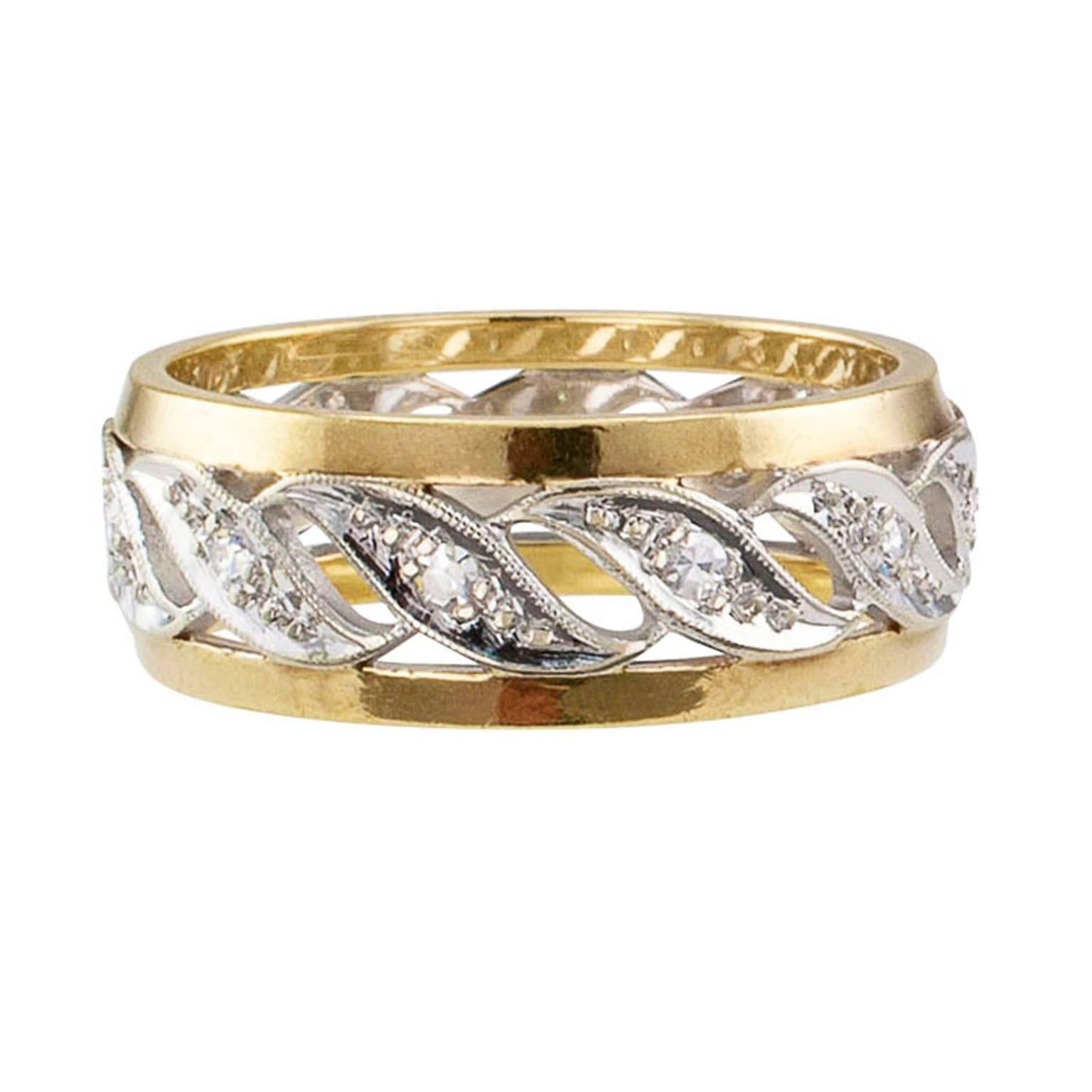 1940s Two tone Gold Diamond Wedding Band

Retro two tone 14 karat gold and diamond wedding band circa 1940.   A continuous row of open work white gold paisley motifs, each centering a single-cut diamond, between parallel bands of yellow gold.  A