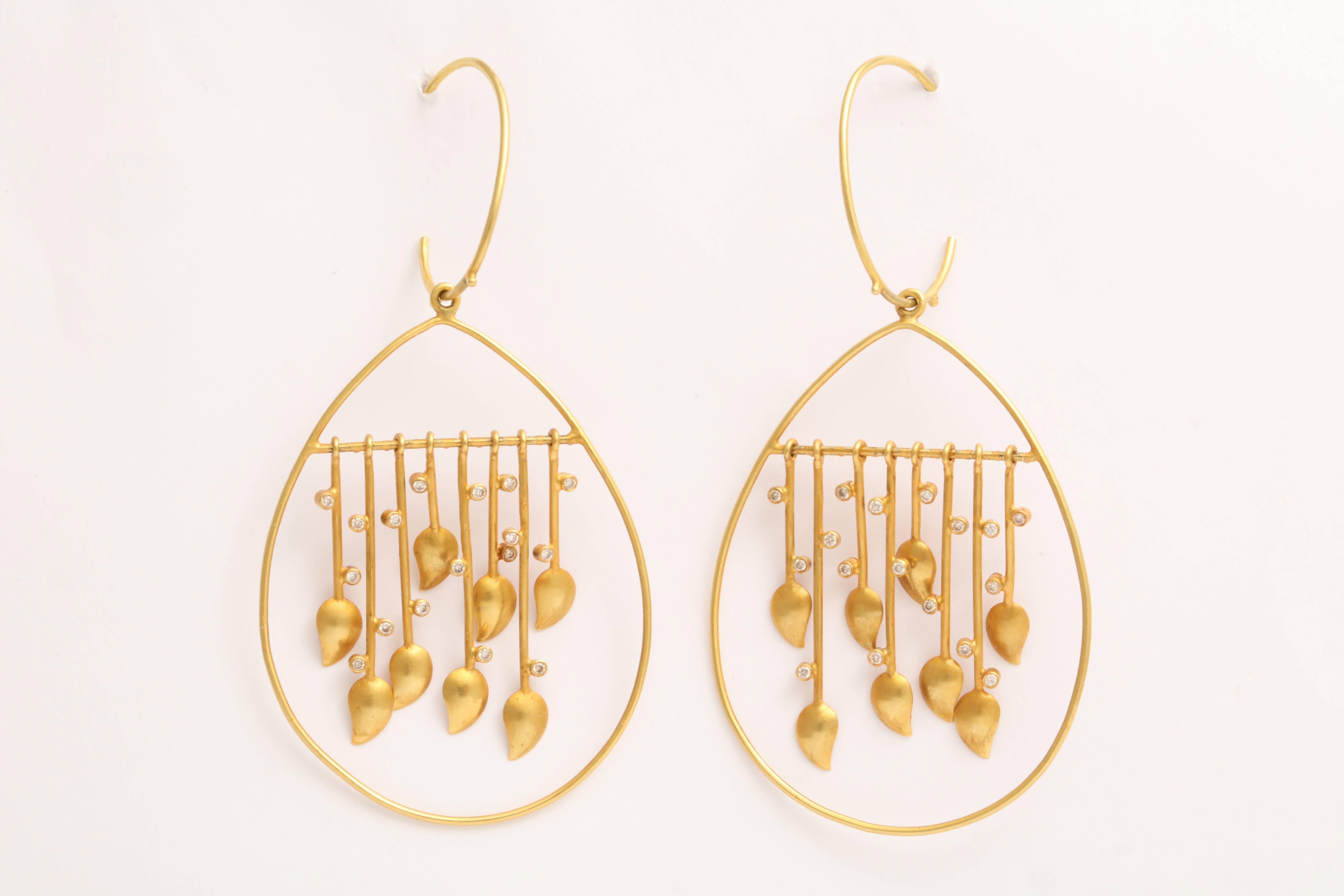 
A pair of 18kt yellow gold and diamond raindrop earrings. Each drop showcases a suspended row of 18kt yellow gold and diamond drops that swing when being worn.  There are approximately .22ct of diamonds.
length: 2.65 inches
width: 1.35 inches