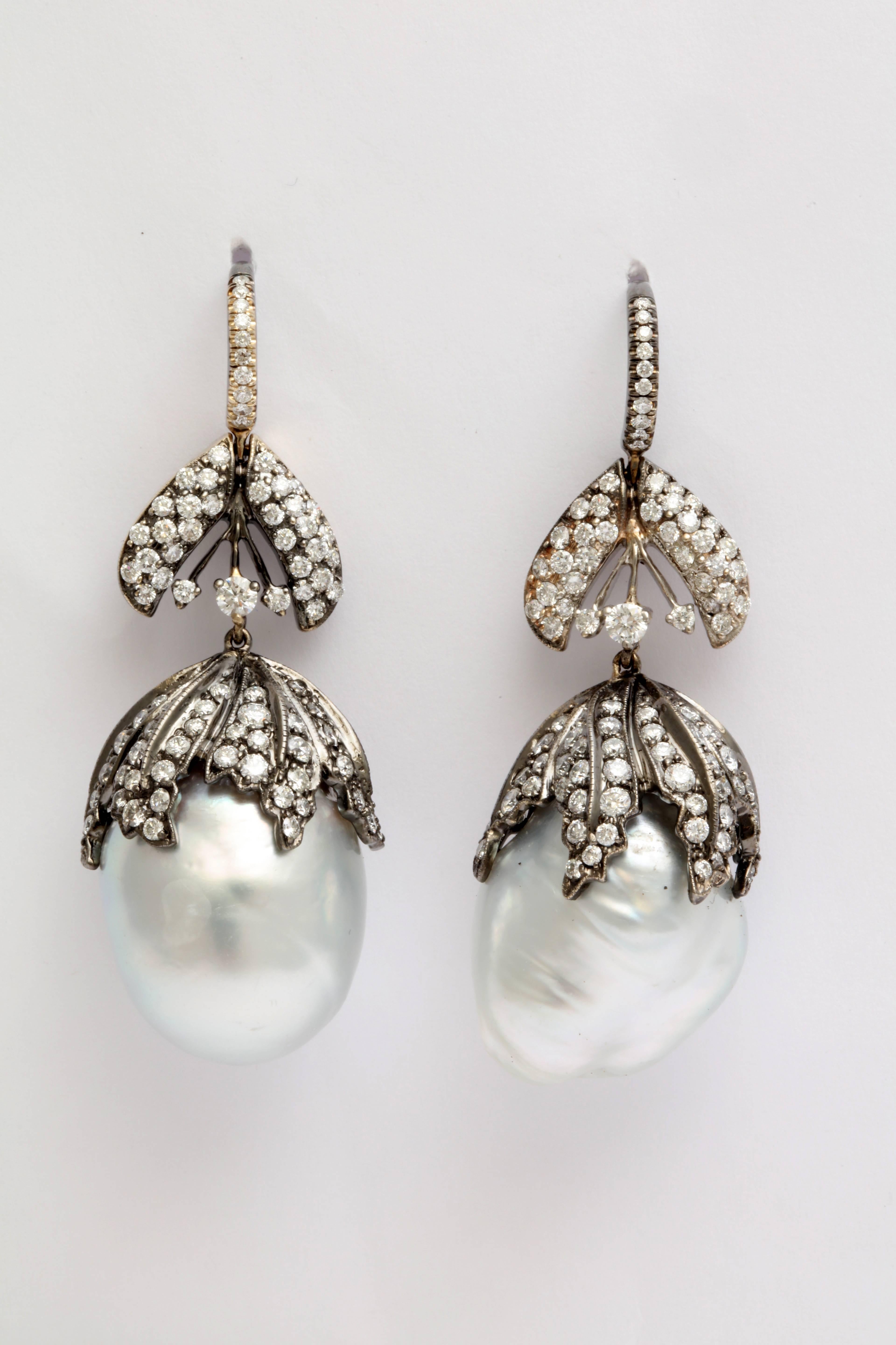 A pair of South Sea baroque pearl and diamond earrings. The earrings are composed of baroque pearls with 18kt white gold and diamond leaf caps that are suspended from18kt white gold and diamond leaf ear wires.
Length: 2.10 inches
Width: .80 inch
