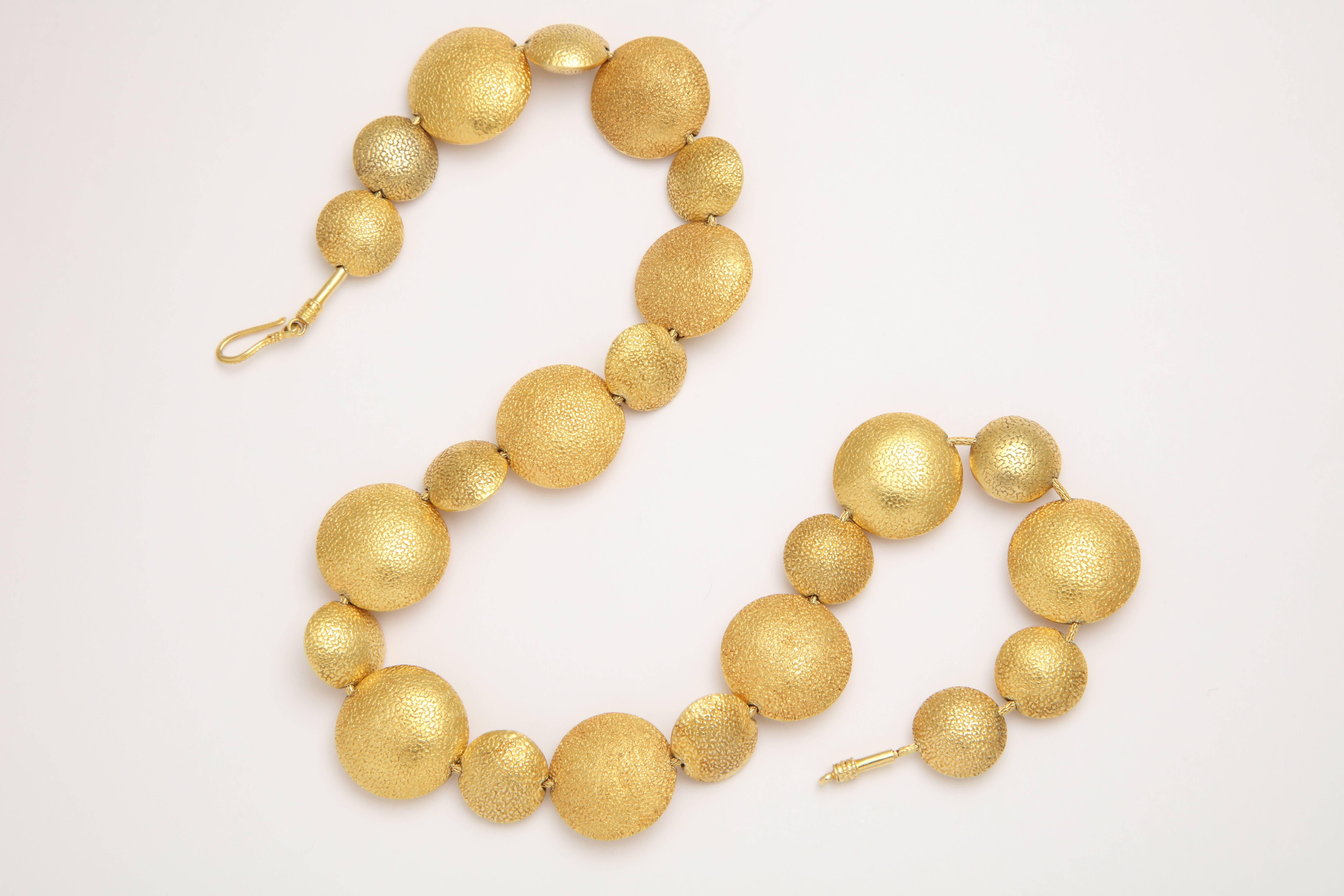 A necklace composed of 23 18kt yellow gold smartie beads. The beads are strung on an 18kt yellow gold snake chain.

Length: 18 inches
width of large bead: 1 inch
