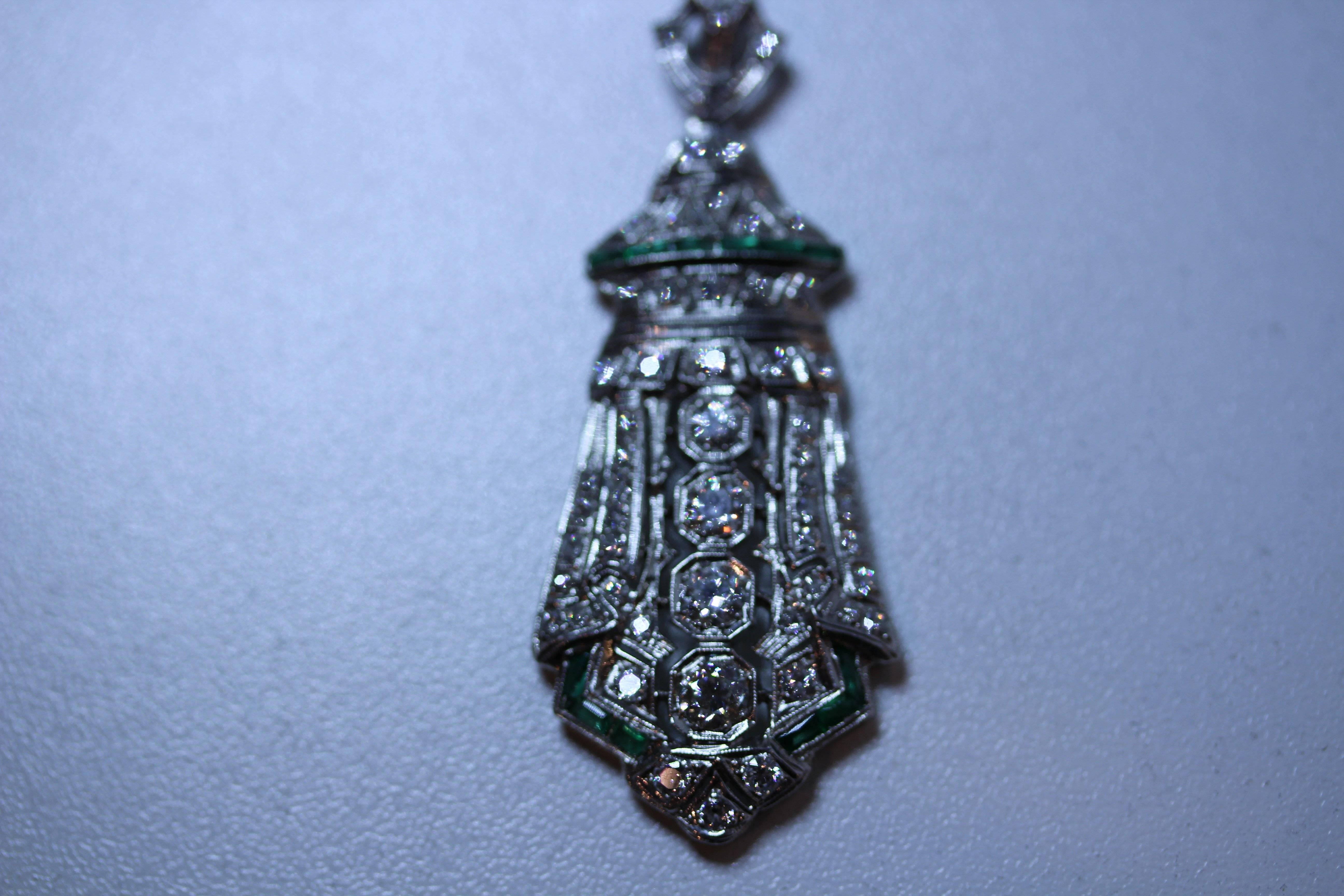 Vintage Diamond and emerald shield shaped pendant. The pendant has 4 round
diamonds weighing approximately 1.14tw with smaller diamonds weighing 1.06tw. The emeralds weigh .55tw approximately. 30 inch chain, 