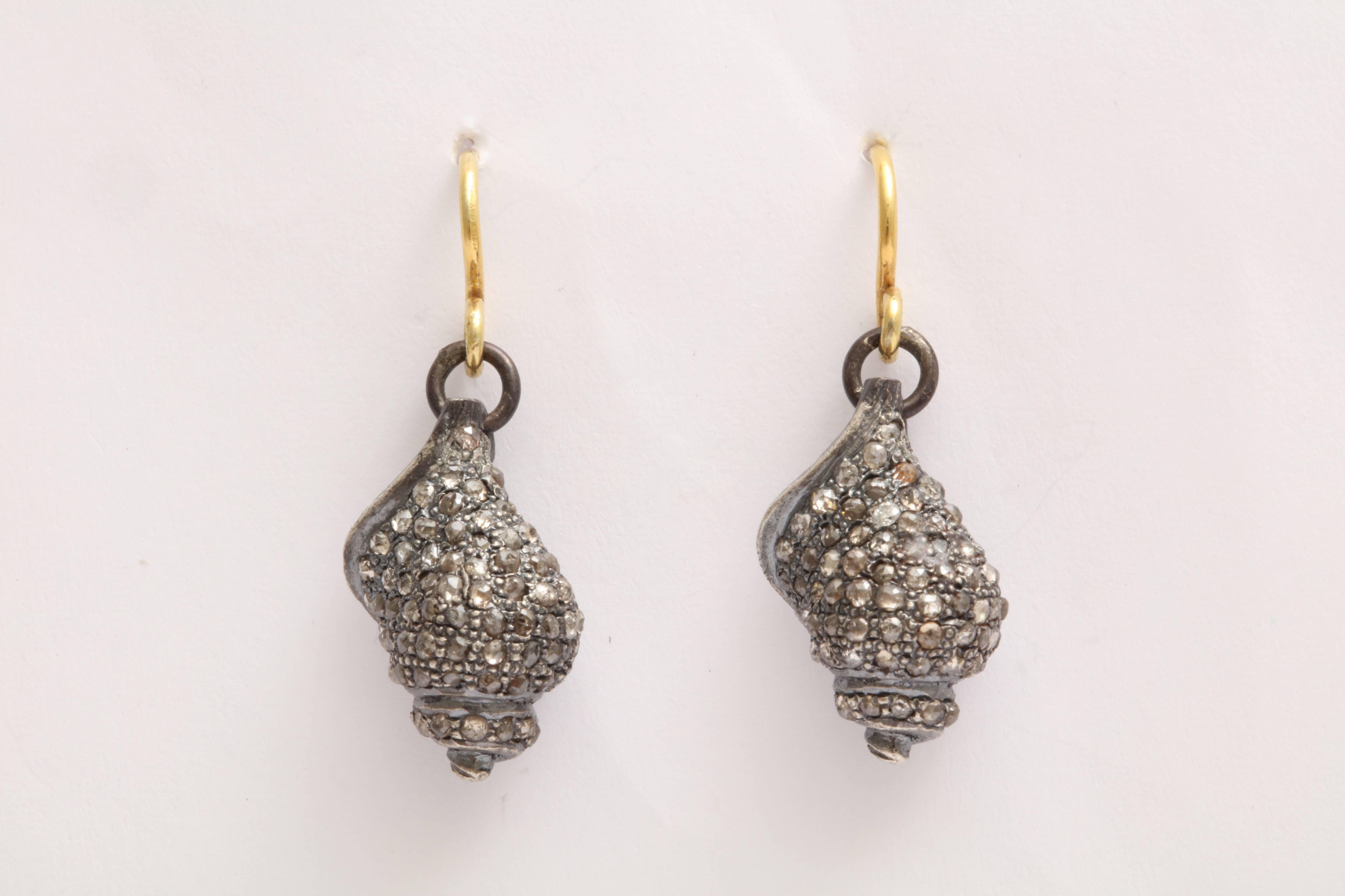 A pair of rhodium plated sterling silver and diamond seashell earrings. The shells are suspended from 18kt yellow gold ear wires. There are approximately 2.56 cts of diamonds.
Length of shell:.75 inch
Width of shell: .50 inch
Length: 1.25 inches