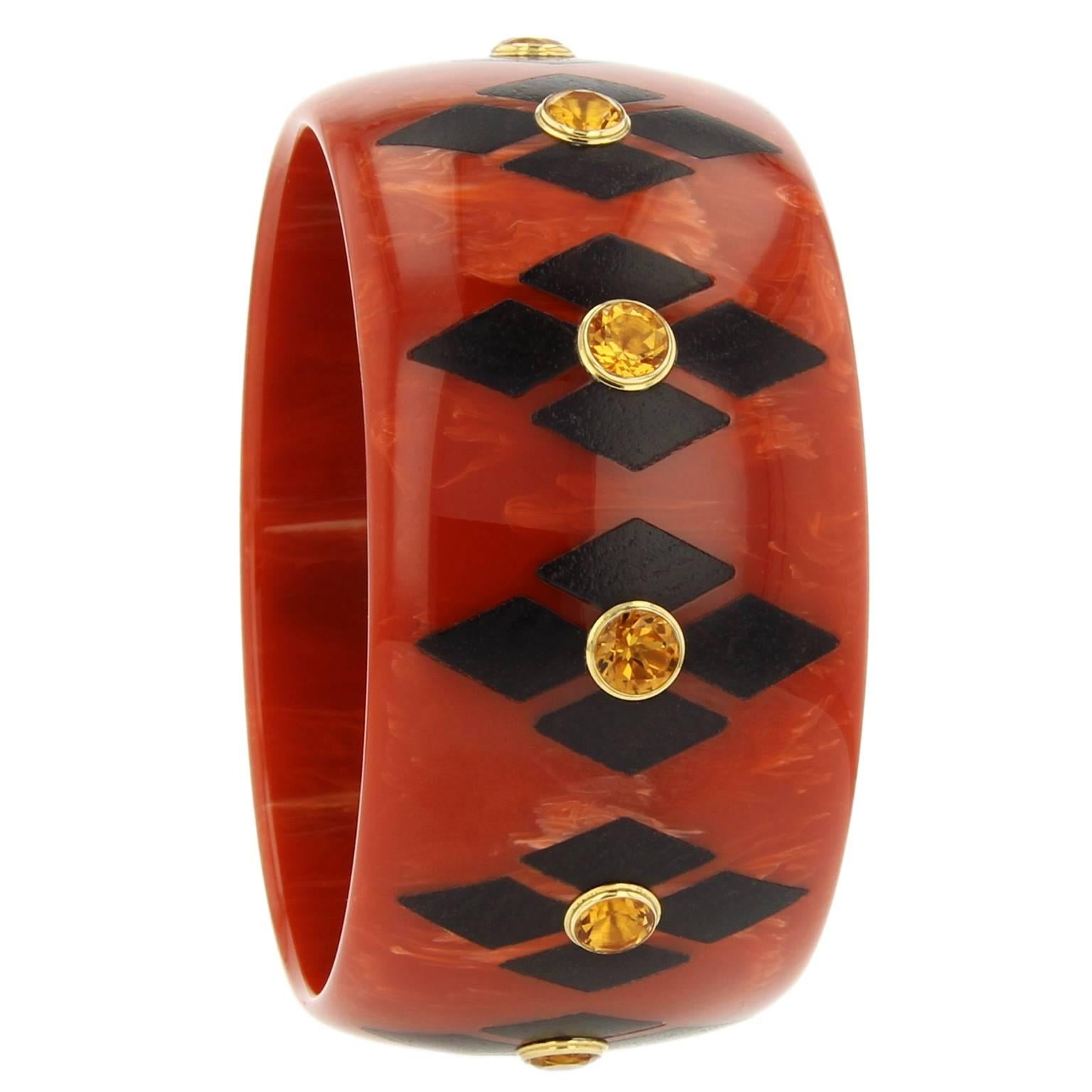 This bangle was handcrafted in New York using marbled burnt orange vintage bakelite.  Part of the Mark Davis Collector line, this bangle is inlaid with a diamond shaped-motif of African Blackwood pieces and studded with citrine bezel-set in 18k