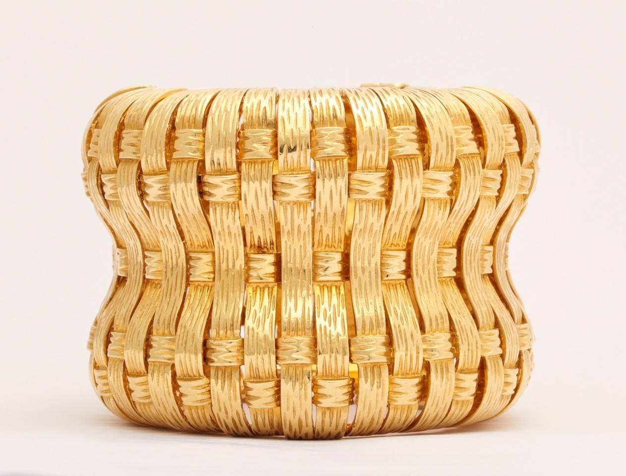A magnificent 1970s large solid basketweave design 18Karat gold cuff bracelet
that has a stunning measurement of a total width of two and half inches wide and eight inches long one inch deep  to accommodate the width and curvature of the cuff. Each