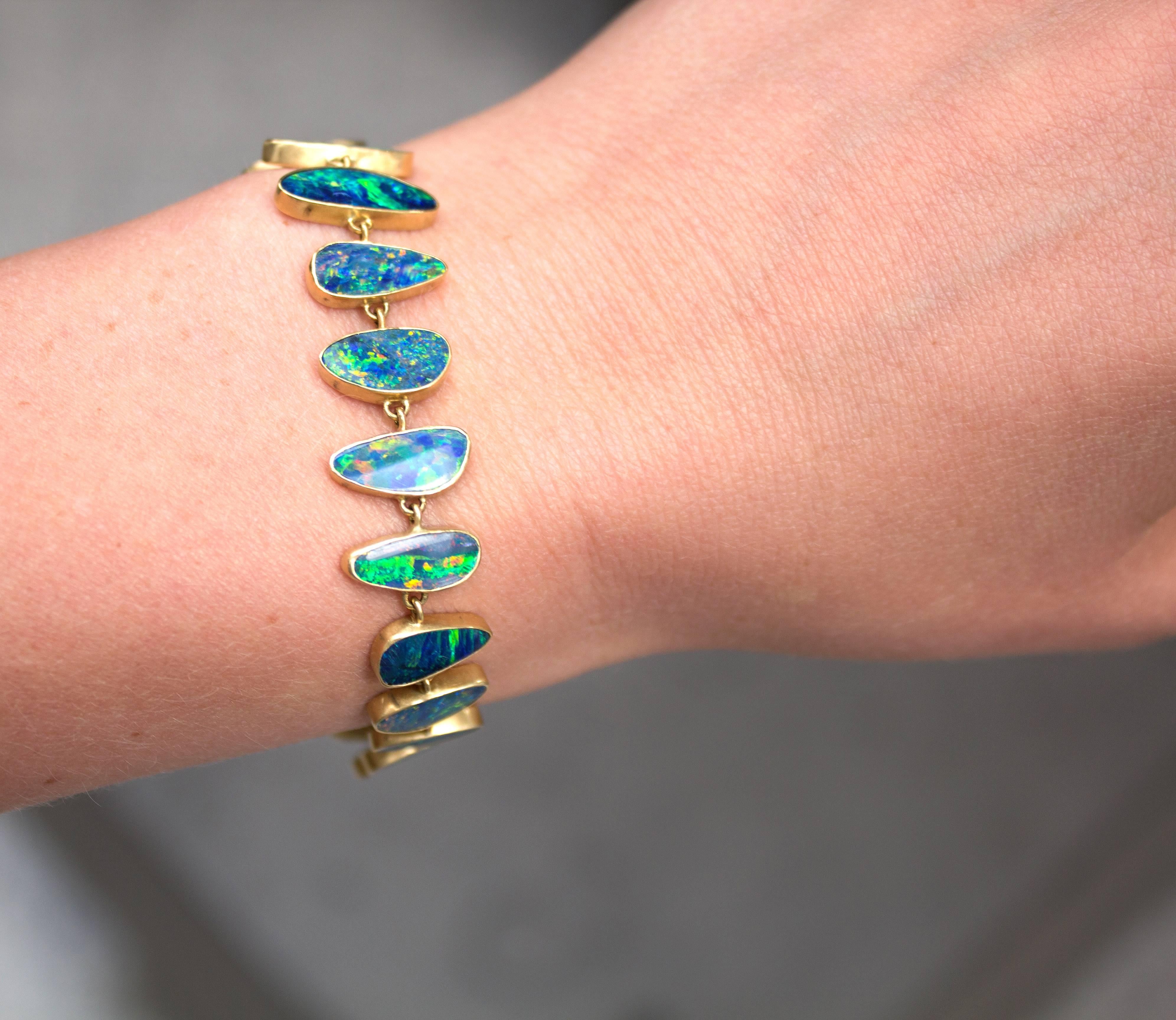 One of a Kind Bracelet handcrafted by acclaimed jewelry designer Kothari in matte-finished 18k yellow gold showcasing 21 beautifully-matched yet individually distinctive boulder opal gemstones featuring vibrant and electrifying play-of-color, all