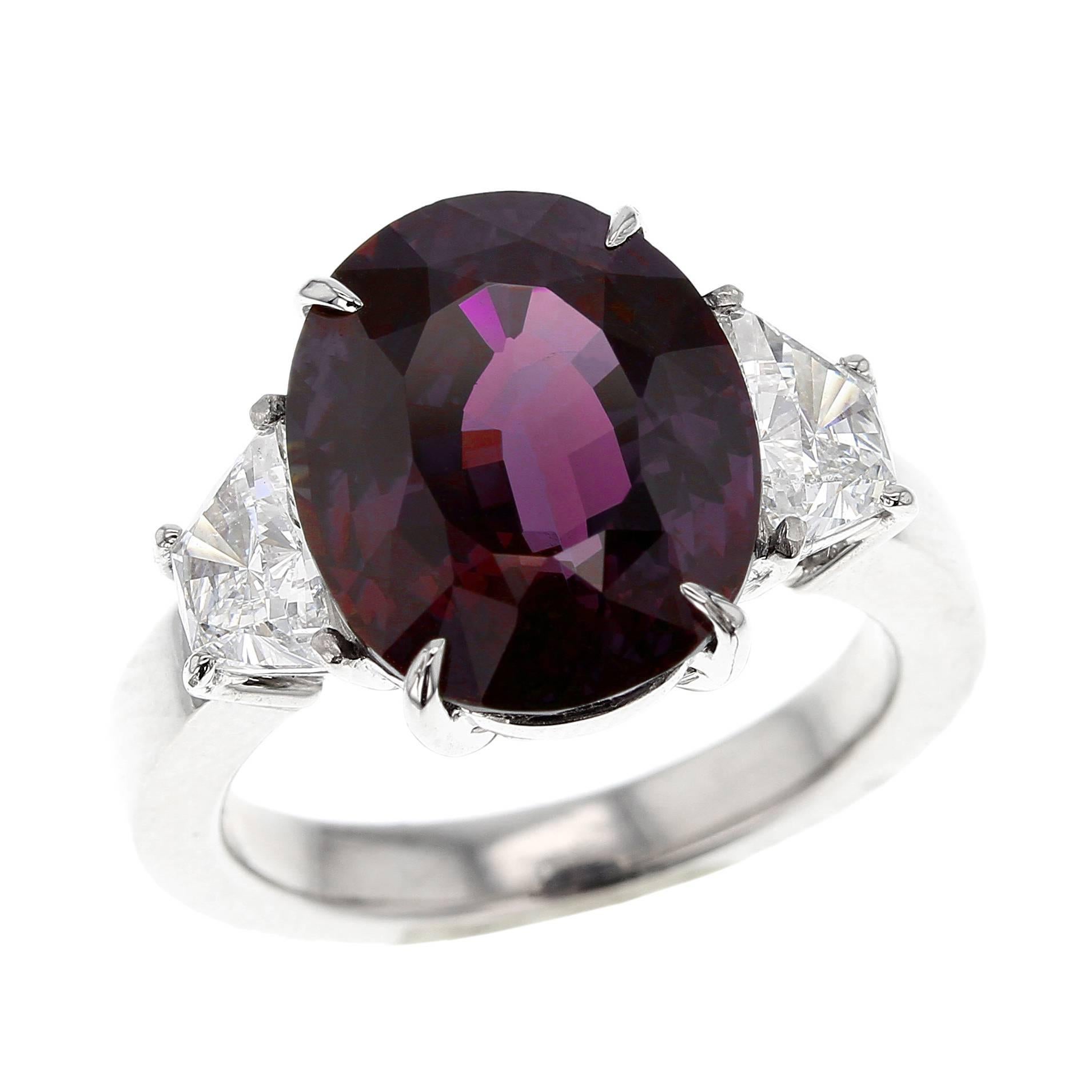 An exceptional and magnificent ring centered with a Brazillian Alexandrite impressively weighing over 8 carats, accented with two trapezoid mixed-cut diamonds weighing approximately 1.03 carats. The center stone accompanies a gemological certificate