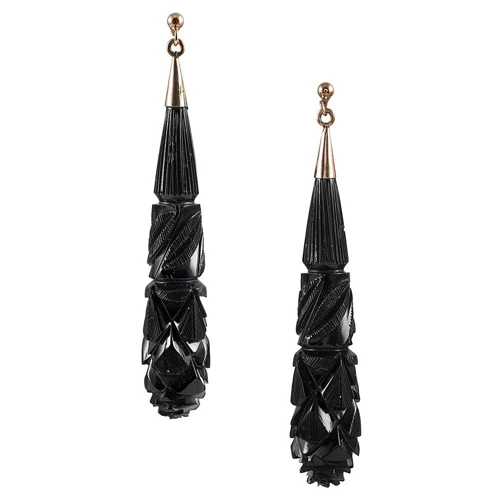 Ornately carved torpedo-shaped earrings of jet are finished at the top with 9 karat yellow gold vintage style screw backs. The earrings can be converted ear wires to accommodate pierced ears on request. 2.5 inches in overall length.