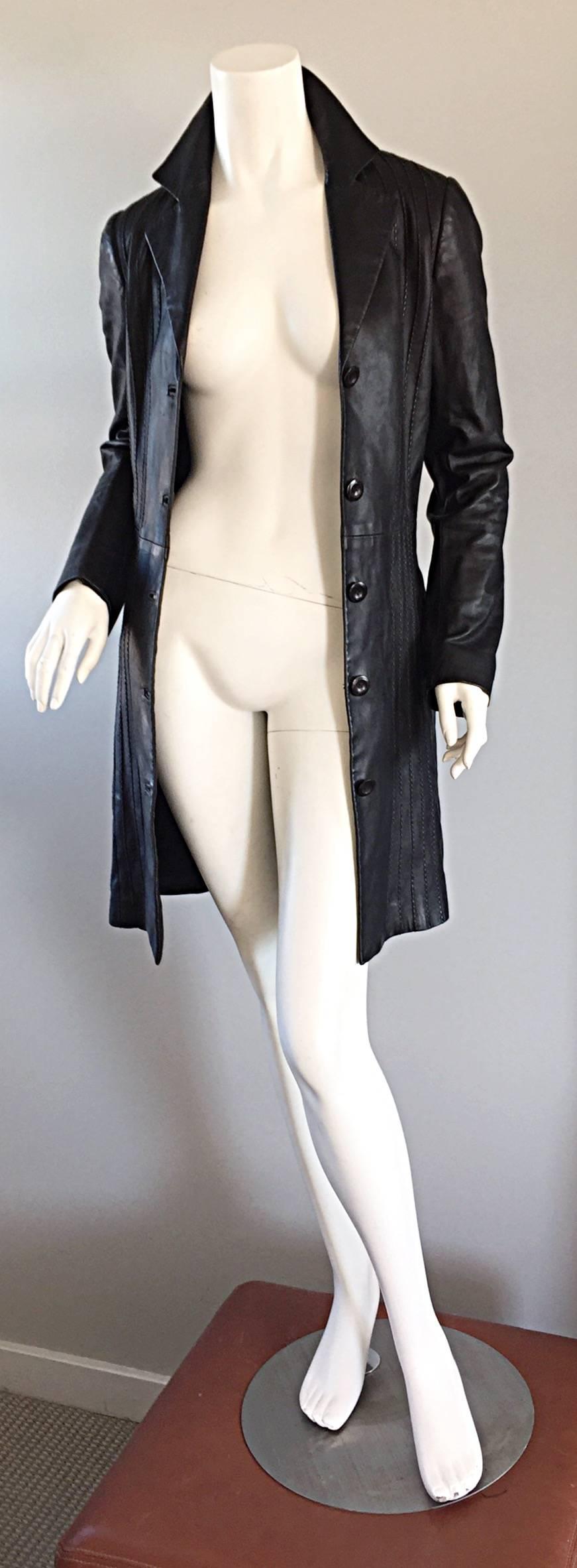 Chic Katayone Adeli early 2000s black leather belted trench jacket! Intricate vertical stitching throughout. Slim fit, that is the perfect everyday jacket! Can even be worn as a dress! Attached belt, with pockets at both sides of the waist.