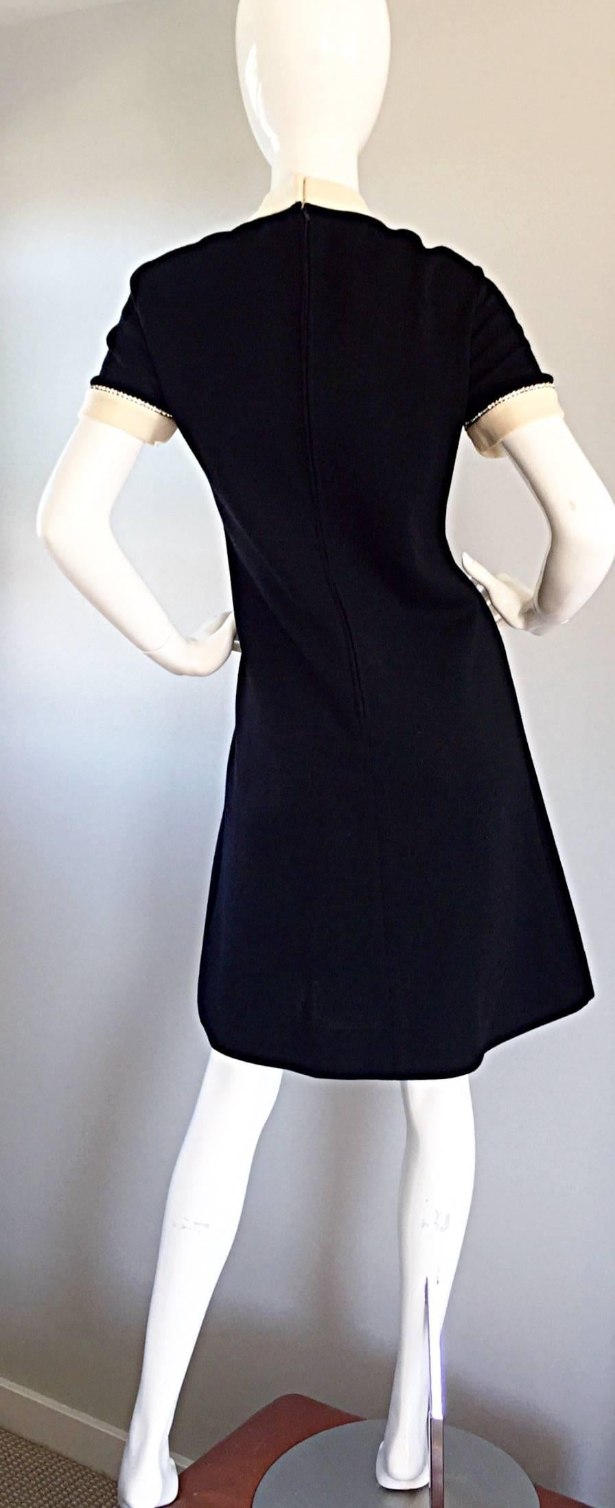 Amazing, and chic vintage R & K Knits black and ivory dress! Encrusted with rhinestones down the center bodice, and around arm cuffs. Classic A-Line shape, that is extremely flattering on! A new, yet classic take on the little black dress. Zips up