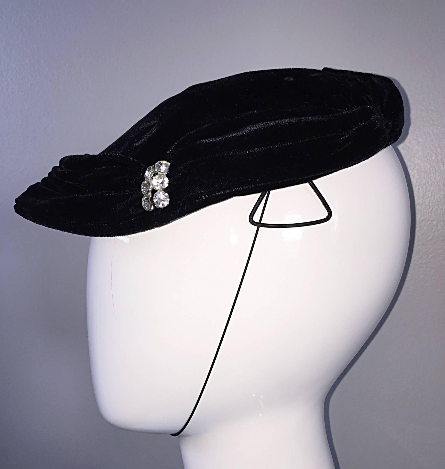 Beautiful 40s vintage black silk velvet hat! Features rhinestones at each front side, with intricate pleating. Chin strap, and side clamps ensures the hat stays on the head. In great condition. Will fit most sizes (Small-Medium/Large)