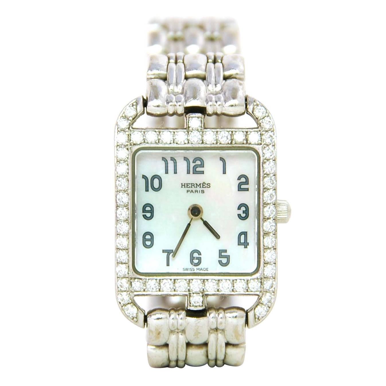 Hermes 18k White Gold & Diamond Cape Cod PM Wristwatch
Made In: Switzerland
Color: Silver
Materials: Mother of pearl, 18k white gold, and one carat's worth of diamonds
Closure: Push spring clasp
Stamp: Face- CC 1.192 1240105, Band- Hermes