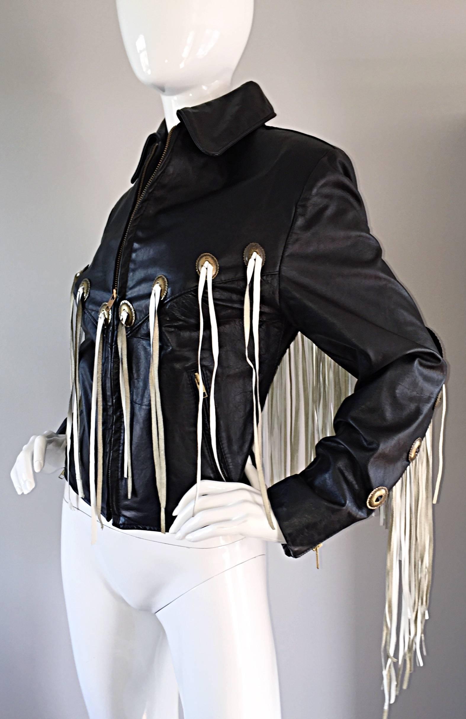 Amazing vintage black leather jacket, with white fringe throughout the front and back! Embellished with brass plates, also on both the front and back. Zips up the bodice. Looks so great on...literally sways with every move, but not in an annoying