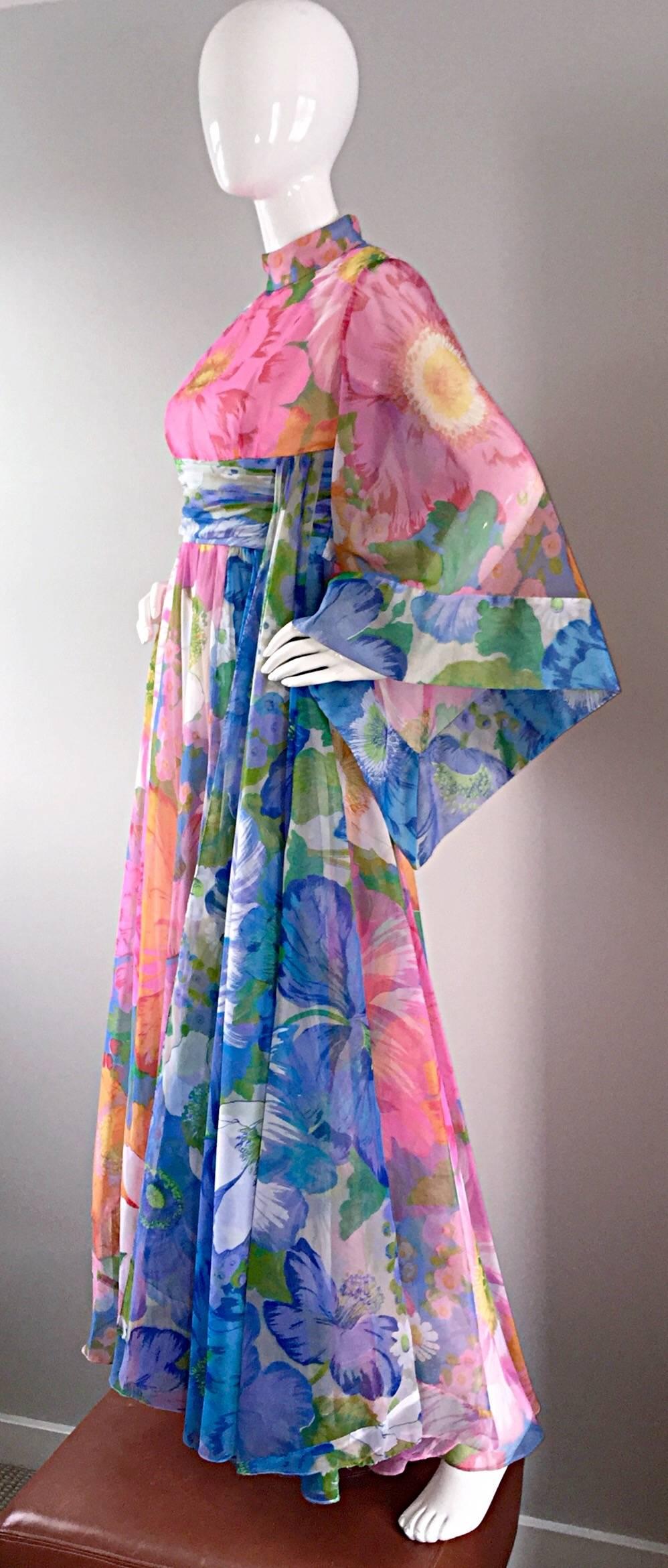 Incredible late 1960s 60s/ Early 70s Mollie Parnis chiffon dress! Features bell scarf sleeves, that are just the right amount of exaggerated! Chic oversized floral print. Fitted bodice, with a full maxi skirt. Contrasting blue floral sash at side.