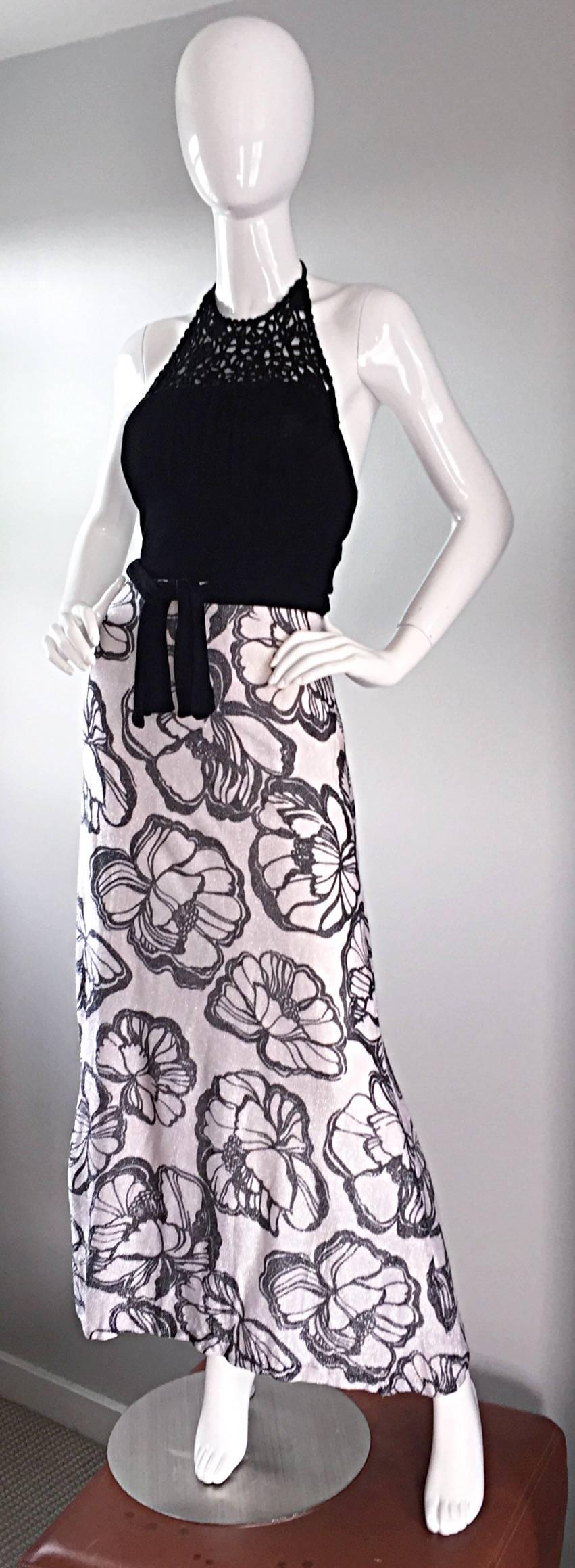 Chic 70s vintage maxi dress! Silver and black metallic maxi skirt, with printed hibiscus flowers throughout. Blak crochet bodice, with attached black sash belt. Ties at top back neck. Fabulous full skirt, that looks smashing on! Hidden zipper up the