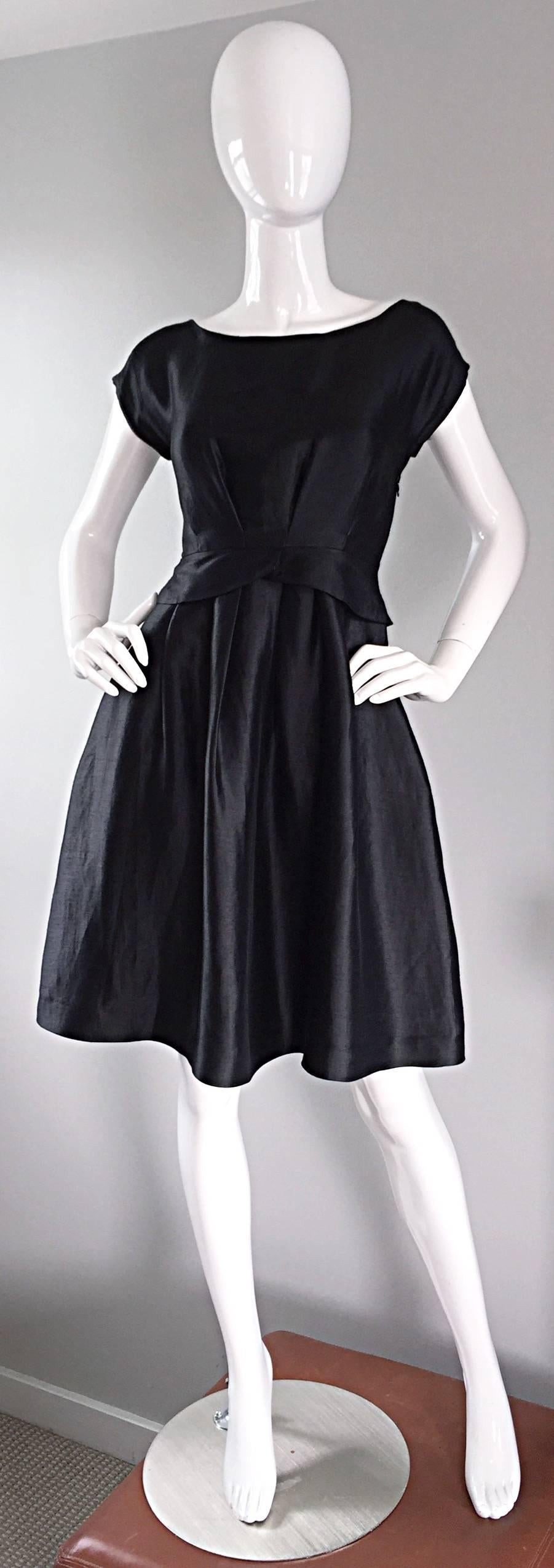 A definite must have for any stylish gal on the go! Moschino black silk dress, that fits wonderfully! 1950s style, with heavy concentration to detail. Slimming waistband, with a fitted bodice, and cap sleeves. Features POCKETS at both sides of the
