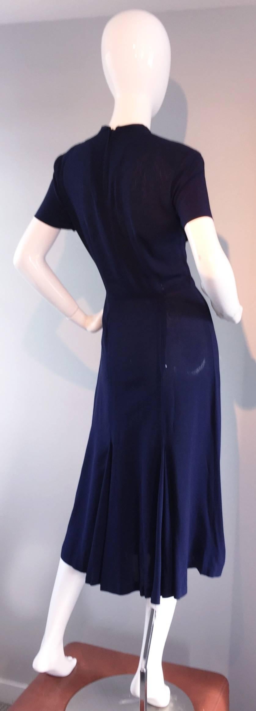 Such a chic vintage 1940s navy blue crepe day dress! Form fitting bodice, with a slight full skirt. Amazing cut-outs above bust, that are lined with nude silk mesh, topped with a spread collar. Expertly sewn, this must be a designer piece, however,