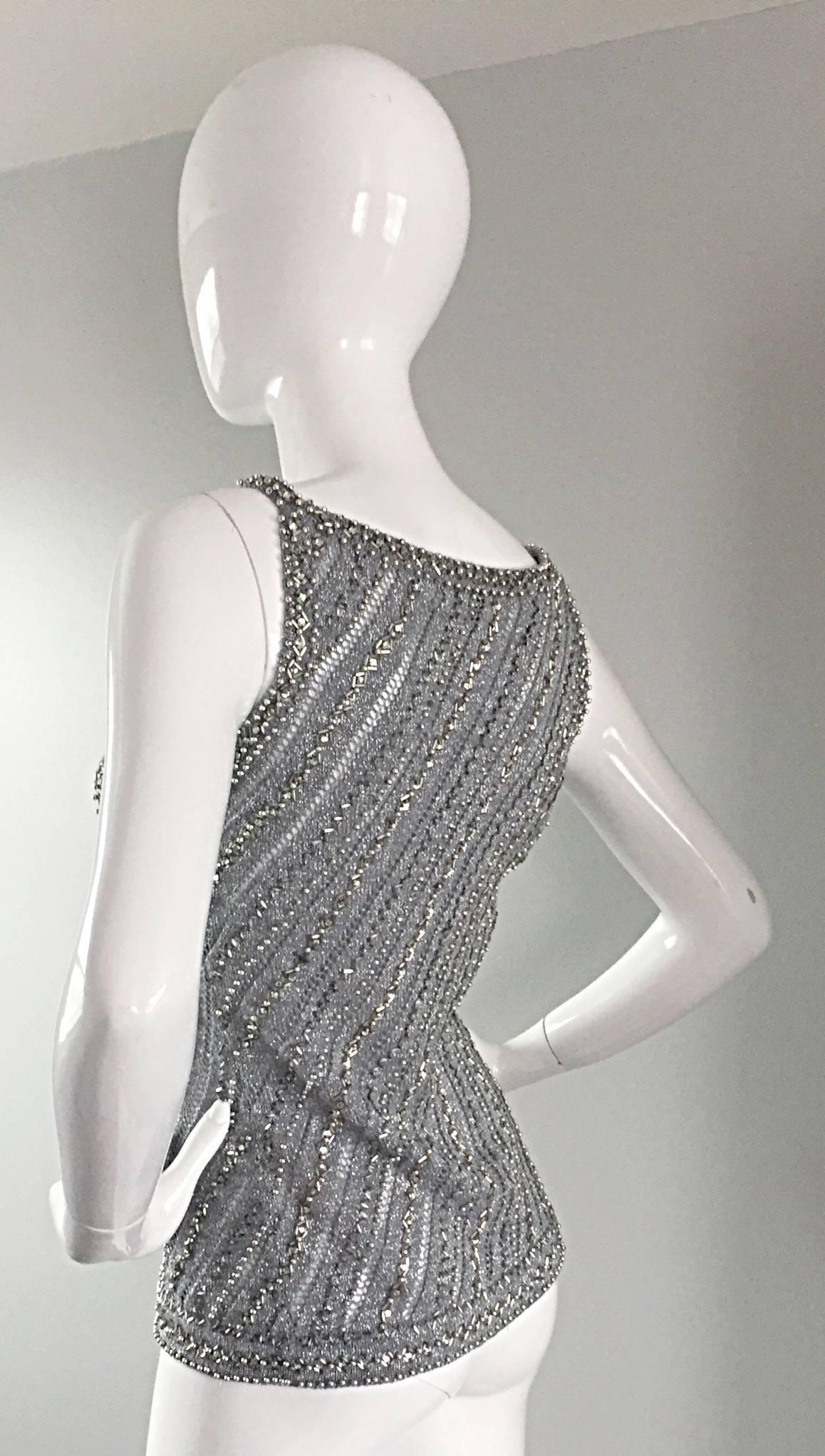 Stunning (and rare) vintage Rizkallah for MALCOLM STARR 1970s gray crochet top! Encrusted with thousands of silver beads and rhinestones throughout the front and back. Crochet detail intermixed. Sleeveless style, with sleeves fully beaded. Couture