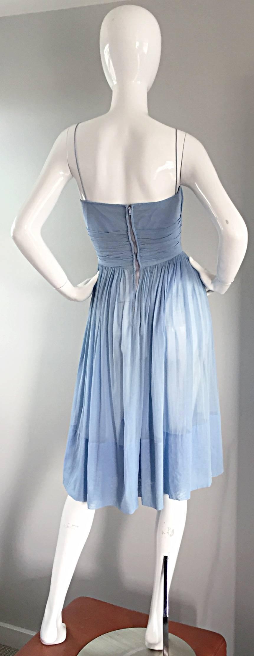 Such a chic and stylish vintage 1950s pale blue, lightweight cotton dress! Features flattering pleating detail at bust, bodice, and skirt. Attached blue and ivory cameo at waist. Extremely well made! Thin spaghetti straps, with an amazing bust cut!